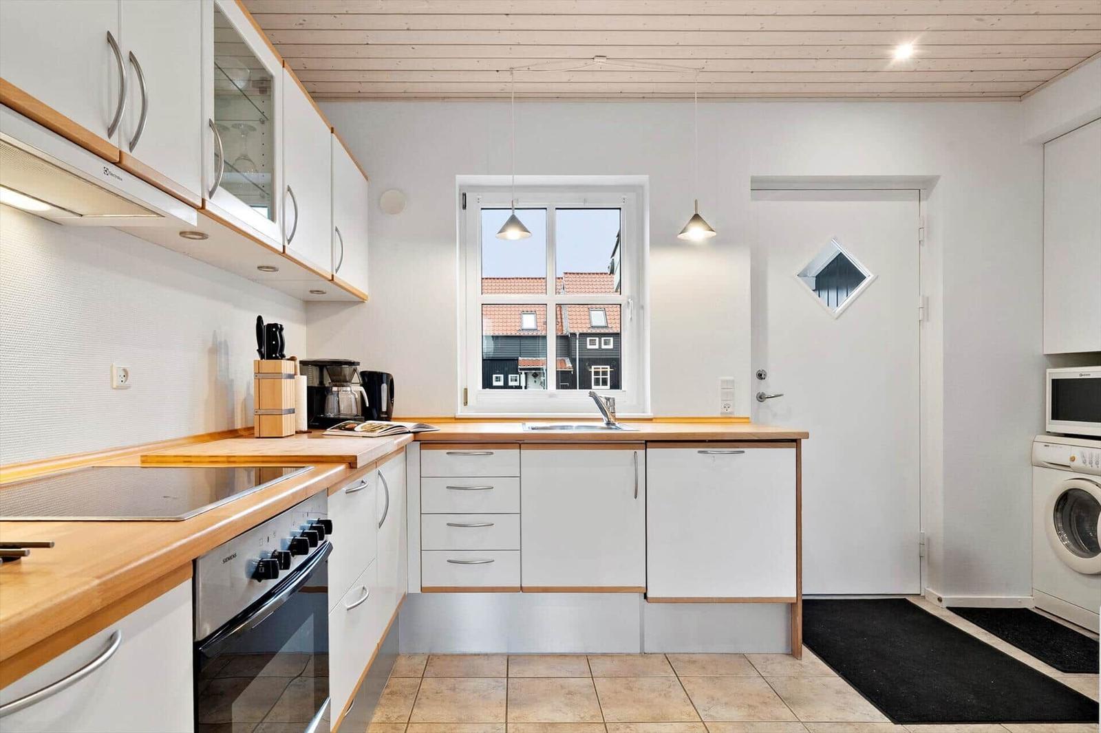 Kitchen with wooden surfaces, window, and washing machine