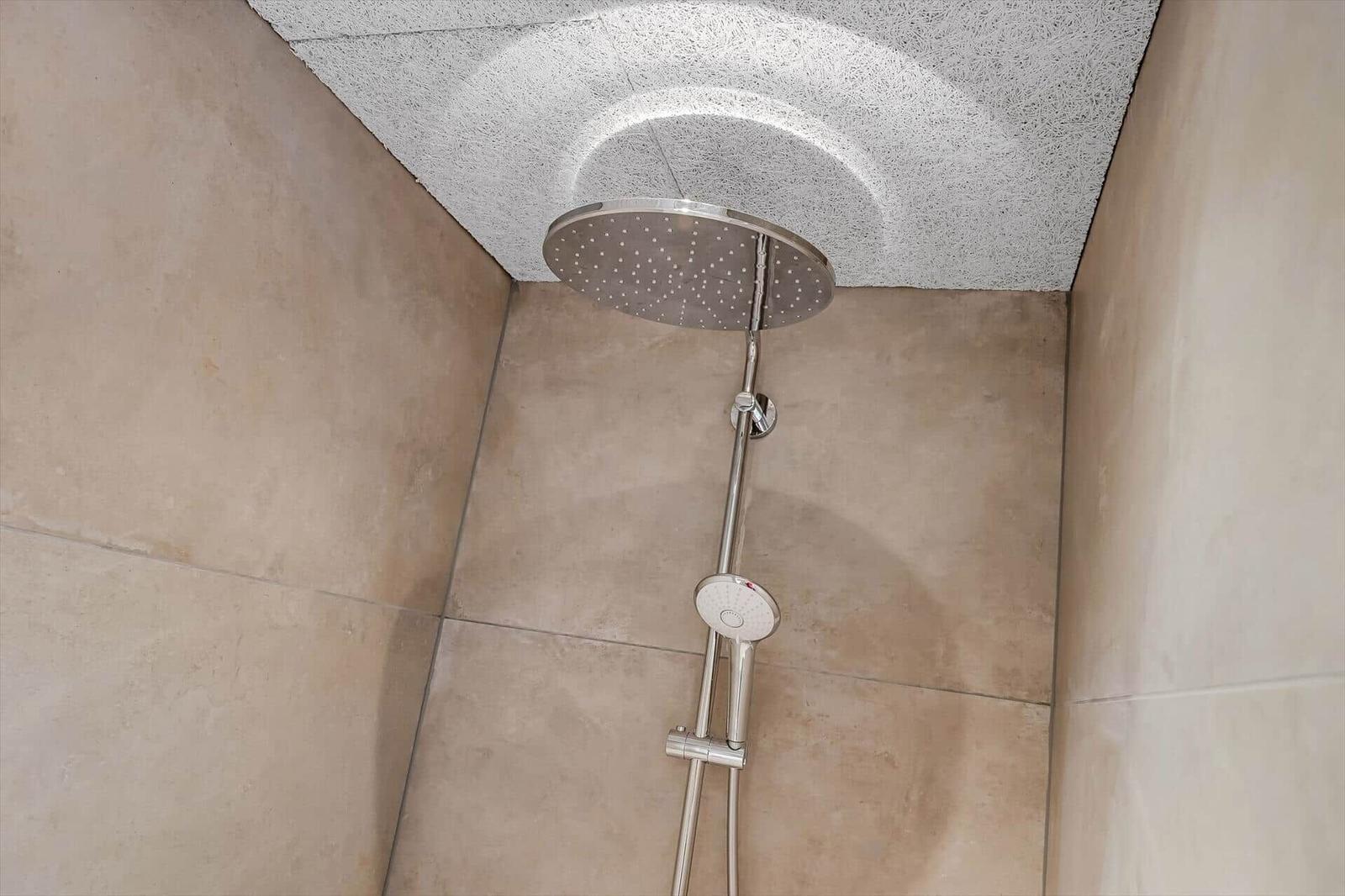 Shower with shower head and handheld shower on wall