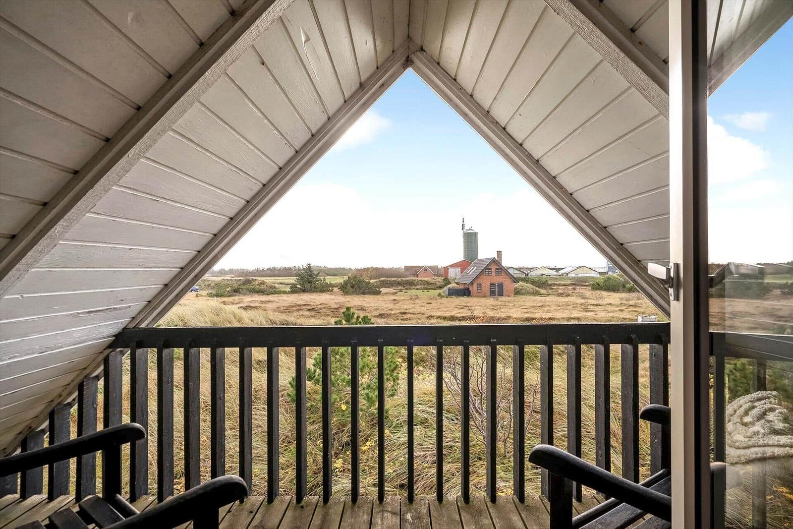 Terrasse mit Blick auf Felder und Gebäude unter einem Dach