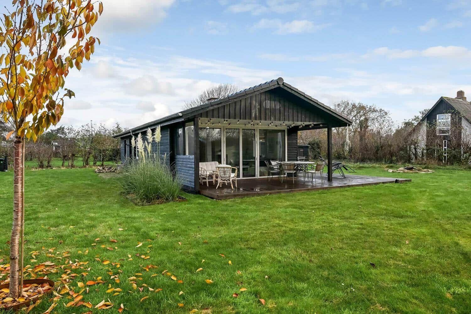 Modern villa with terrace and garden. Glass facade and wooden cladding.
