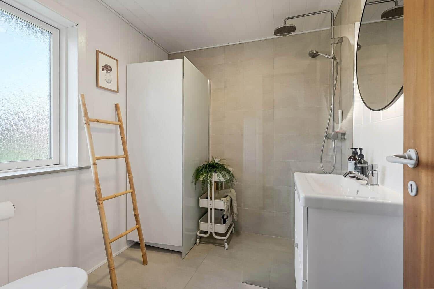 Bathroom with shower, sink, and bamboo ladder.