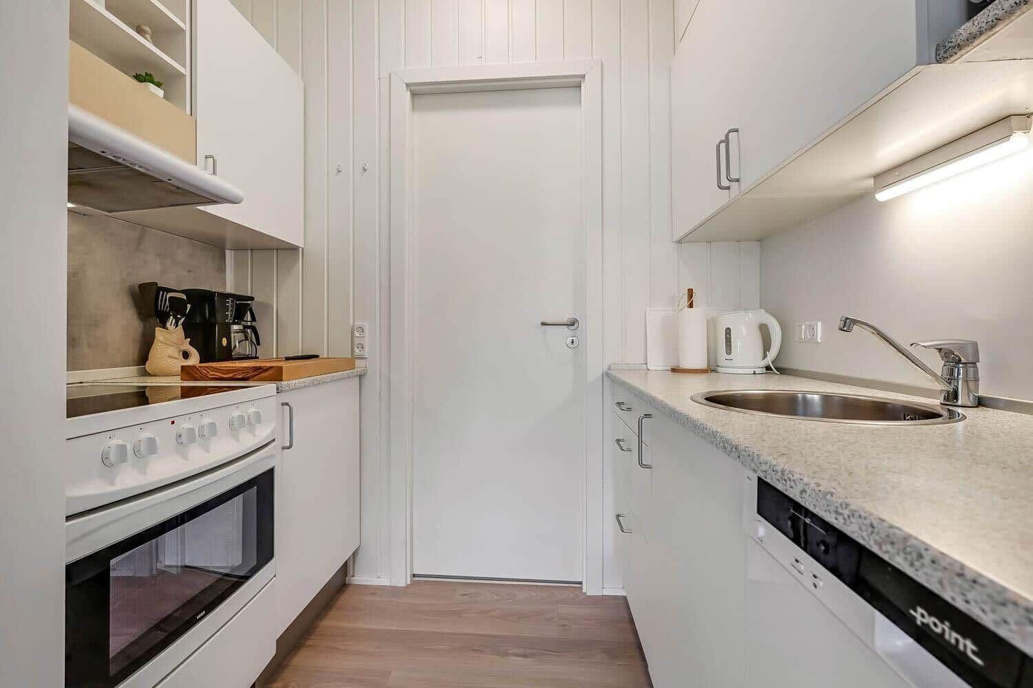 Kitchen with white cabinets, sink, stove, and dishwasher.