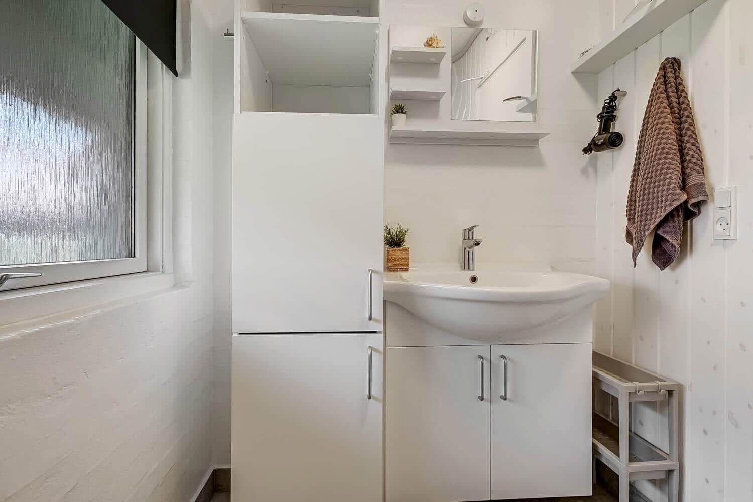 Bathroom with sink, mirror cabinet, and window