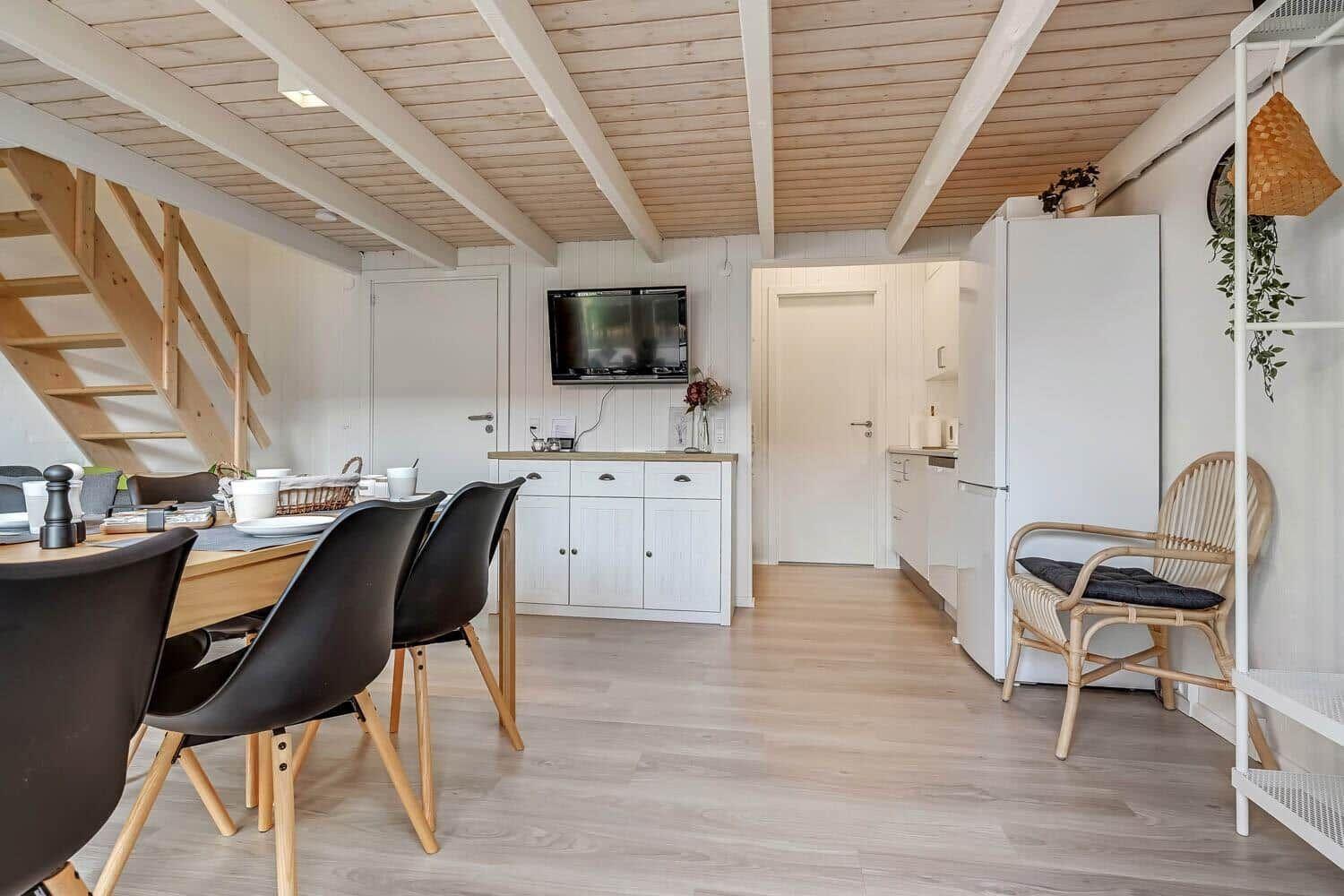 Kitchen and dining area with wooden ceiling and stairs to the ladder.
