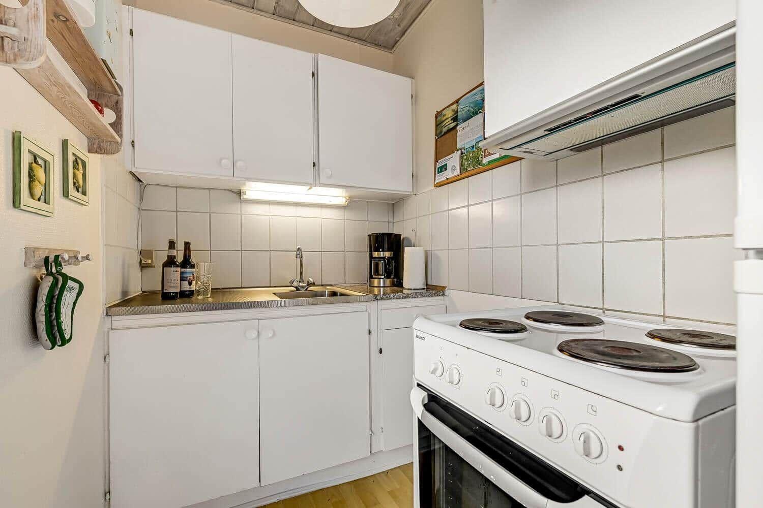 Kitchen with white cabinets, stove, and sink.
