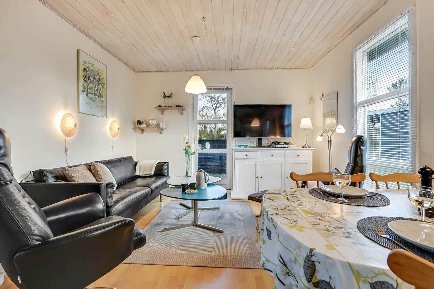 Living and dining area with sofa, TV, and dining table.