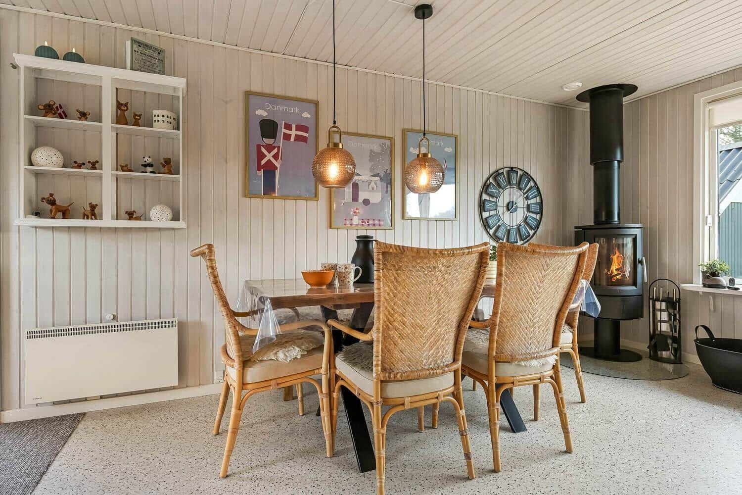 Dining room with table, chairs, and wood stove against the wall.