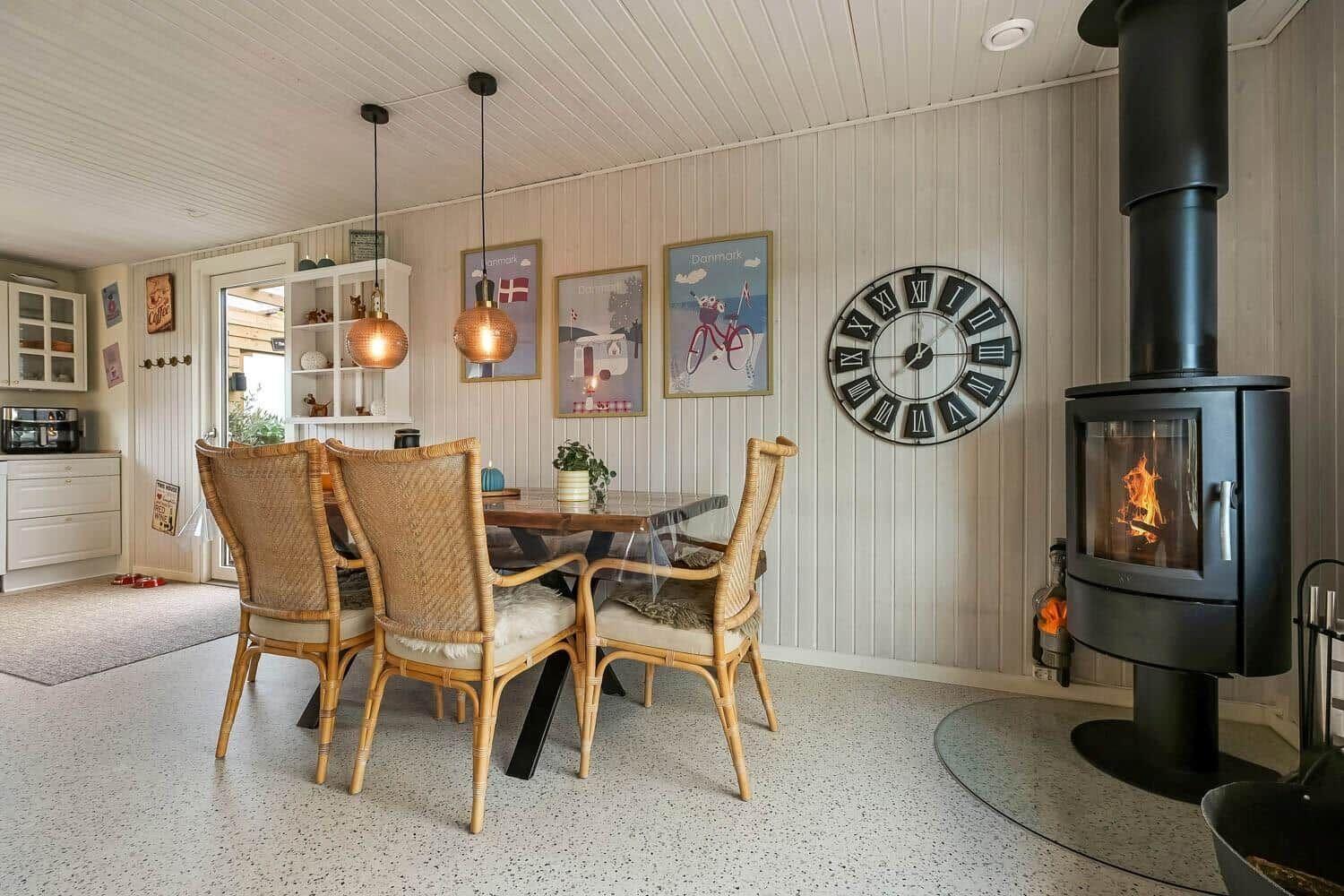 Dining room with table, chairs, and wood stove against the wall.