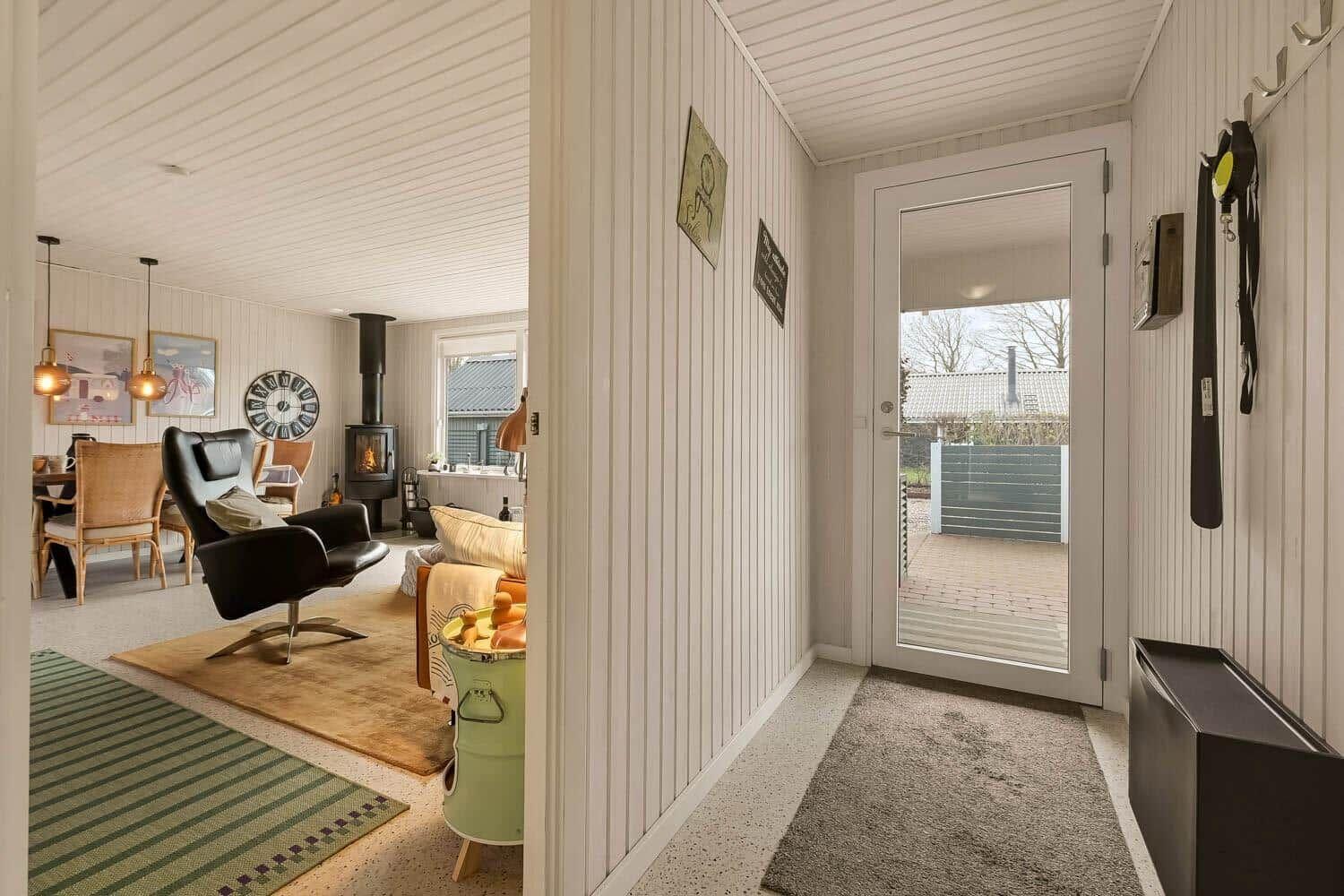 Entrance area with view into living and dining area with fireplace and seating.