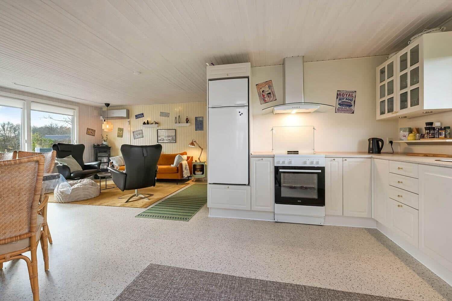 Kitchen with white cabinets and dining area with seating.
