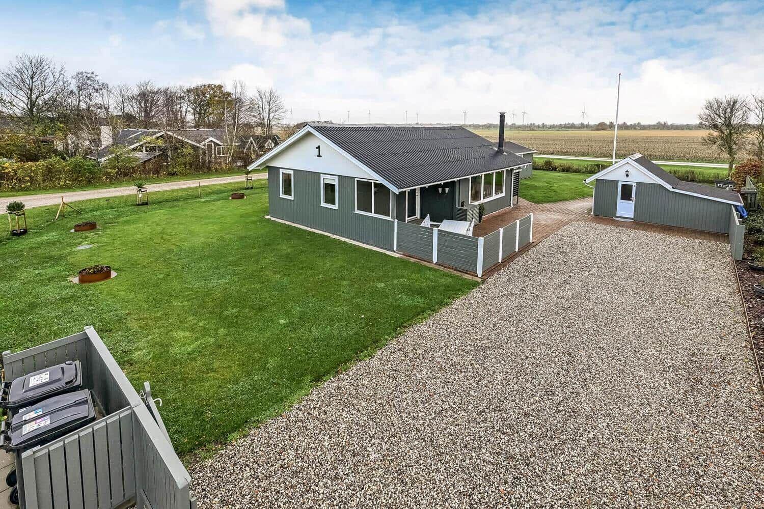 A house with garden and outbuilding. Lawn and gravel path.