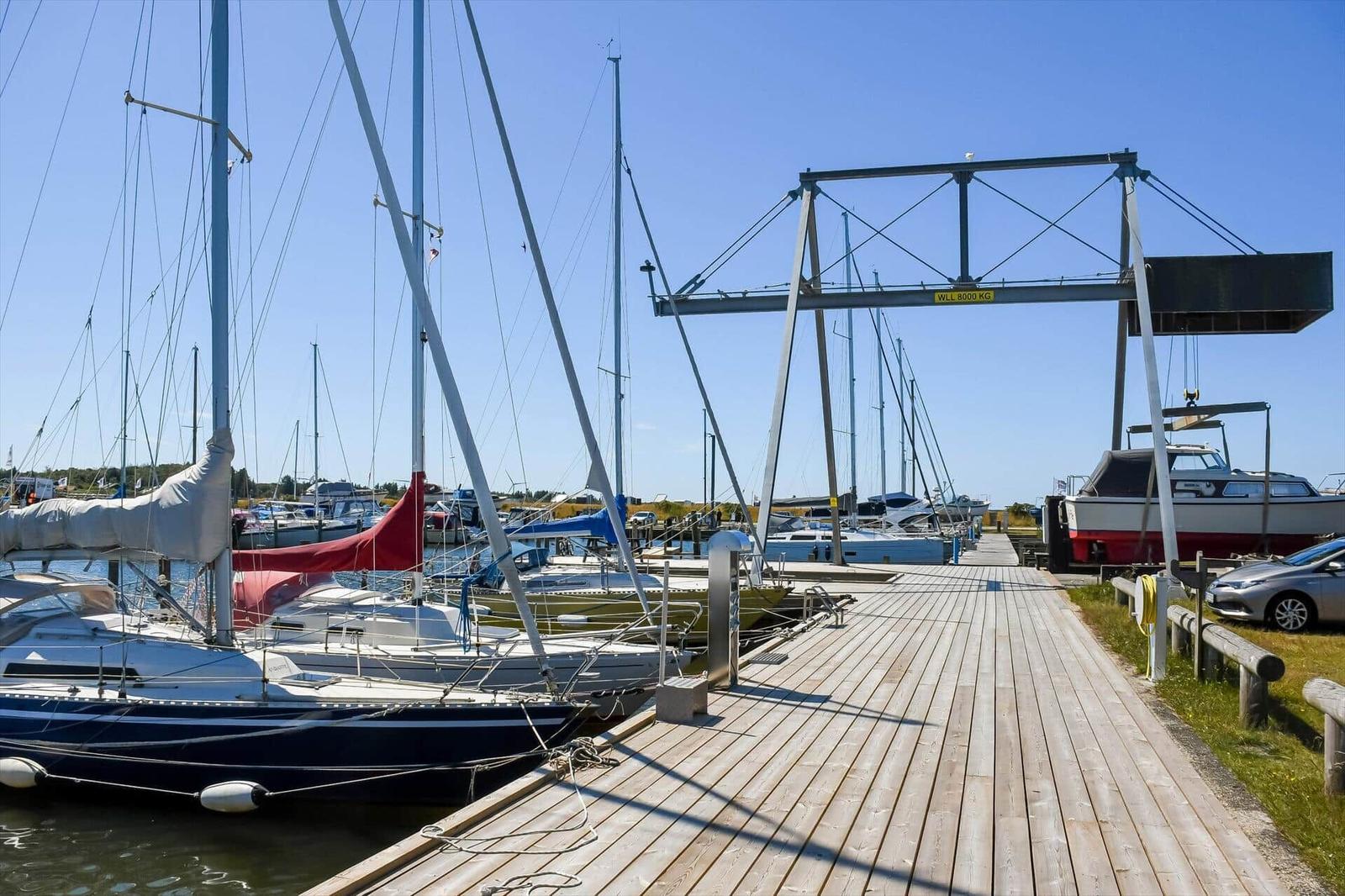 Wooden pier with sailboats and cranes at the harbor