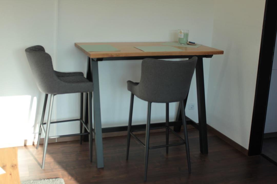 Hochwertiger Esstisch mit zwei Barhockern und einer Kerze.