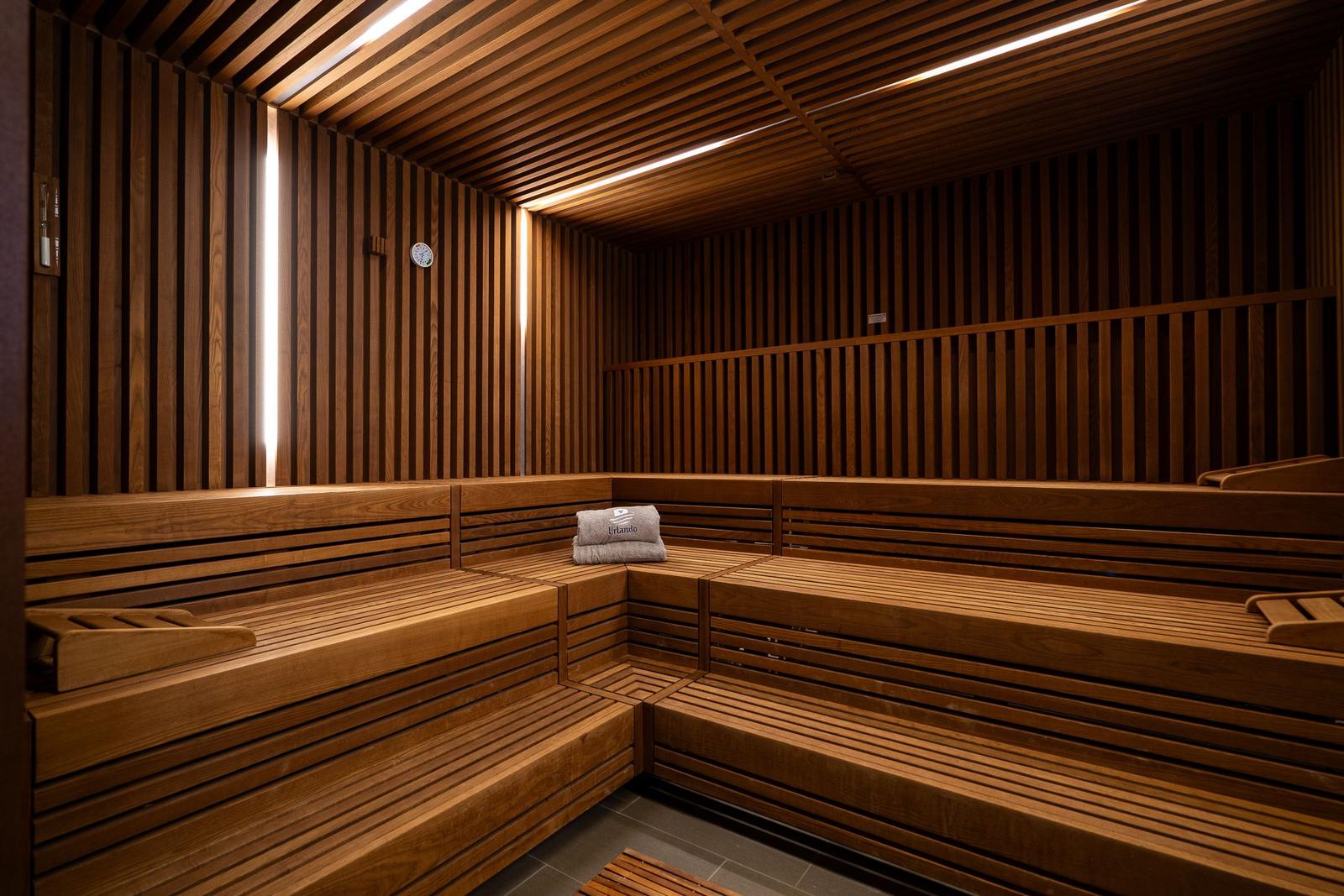 Sauna mit Holzbank und Thermometer an der Wand