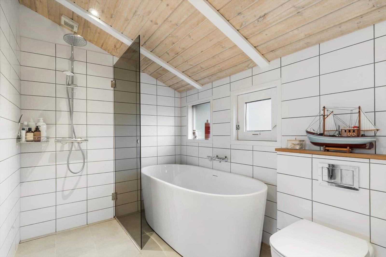 Bathroom with freestanding bathtub, shower, and model boat.