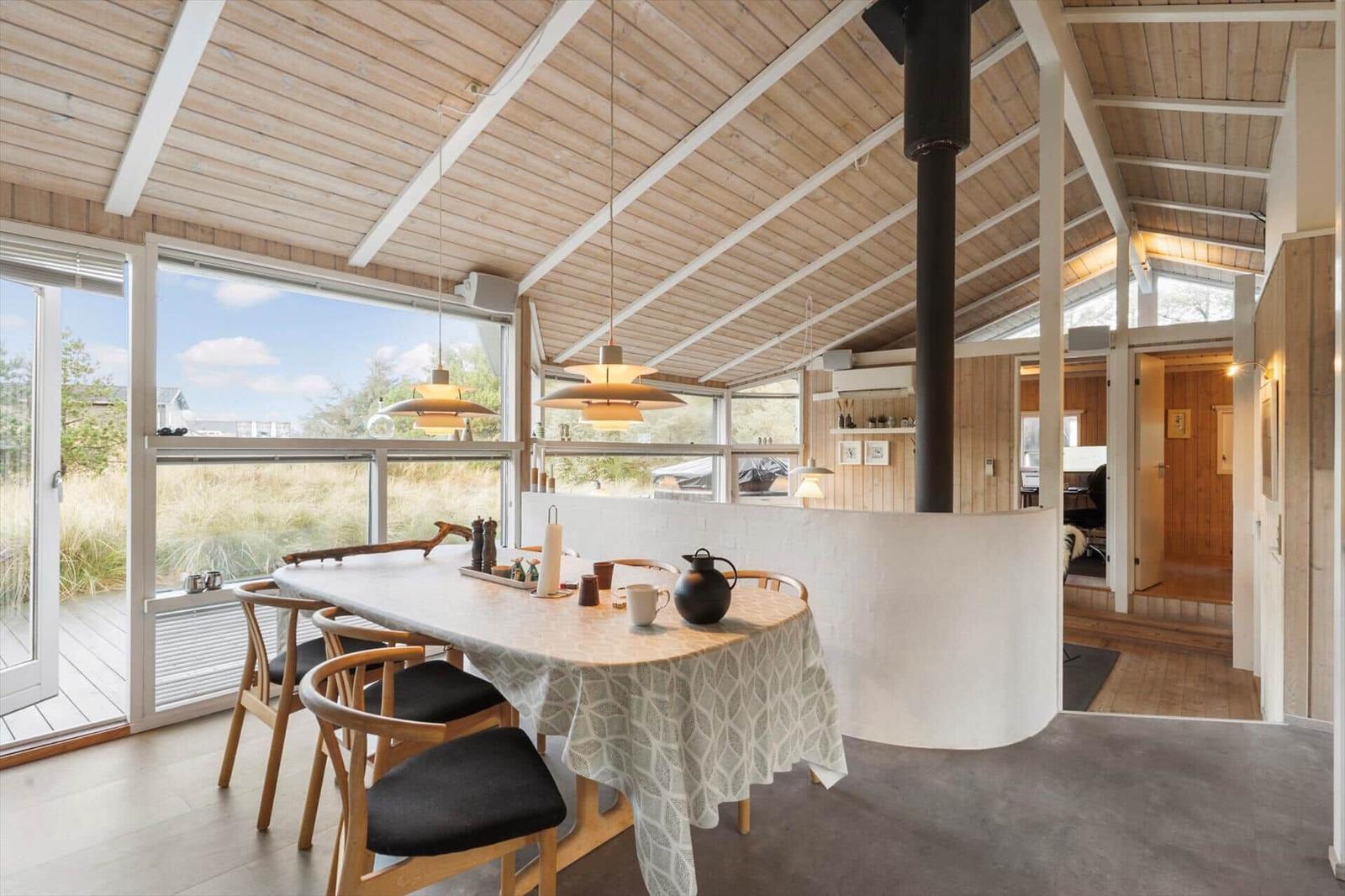 Dining area with wooden table, chairs, and large window view.