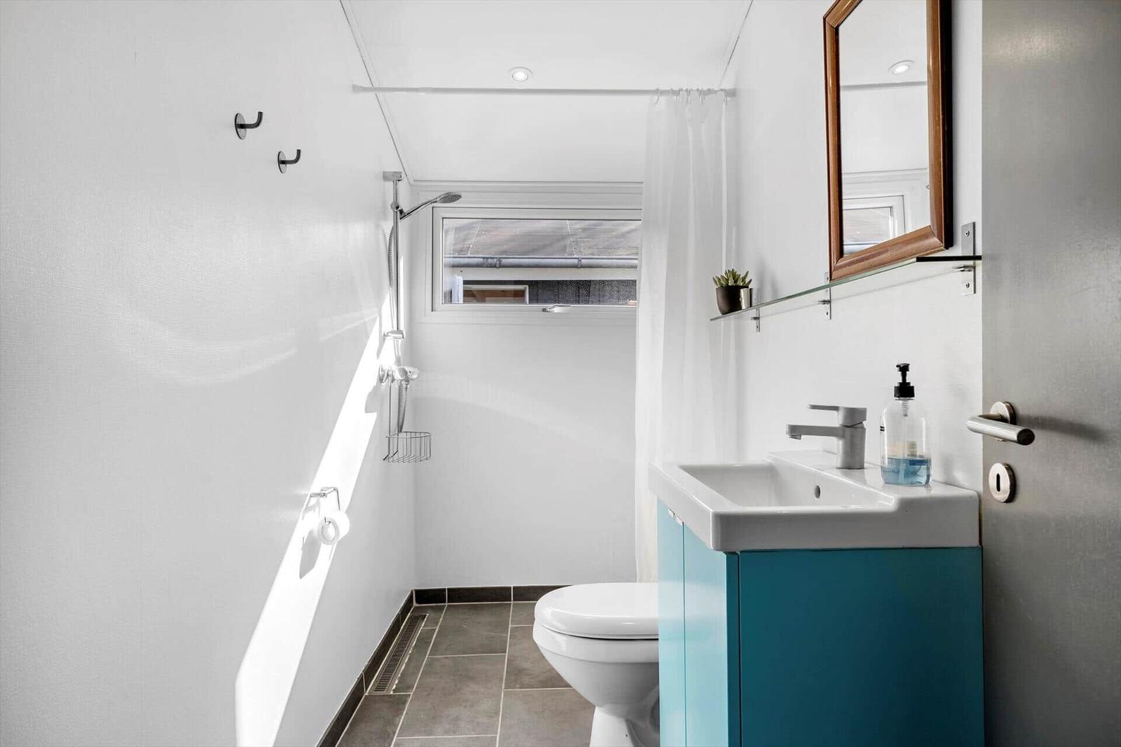 Bathroom with shower, toilet, and sink with mirror