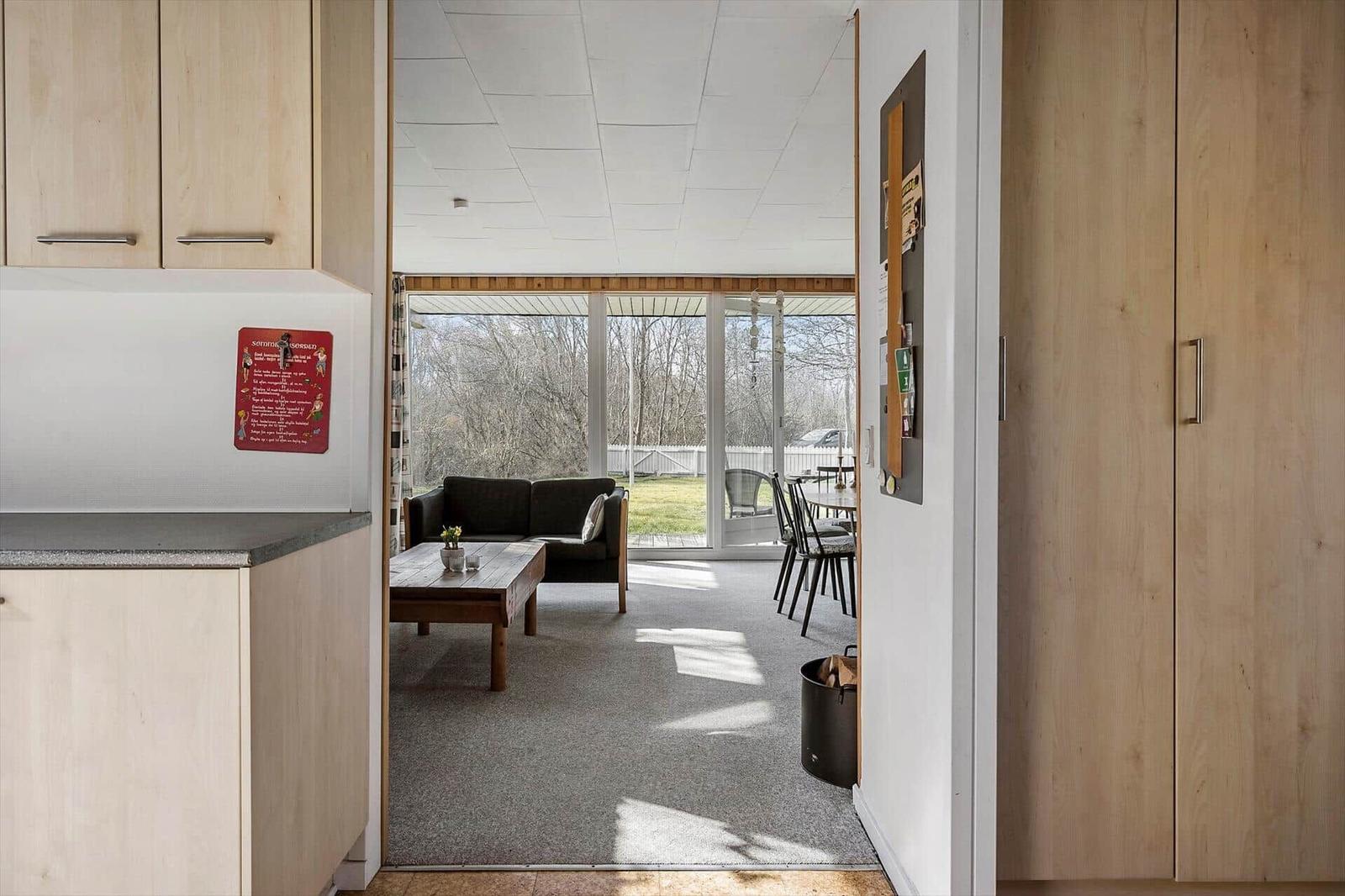 Kitchen with view of living and dining area with sofa and table.