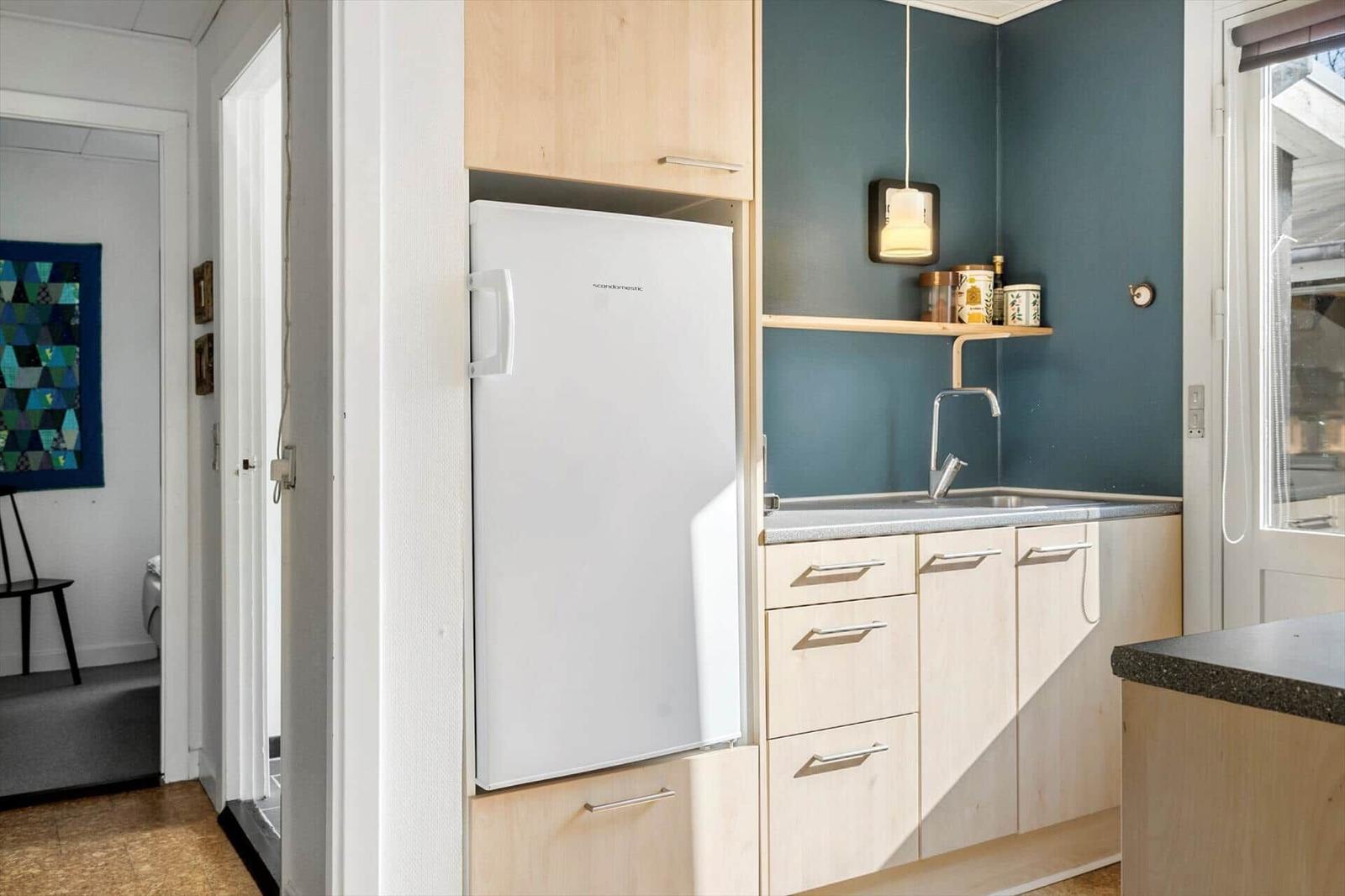 Kitchen with refrigerator, worktop, and sink.