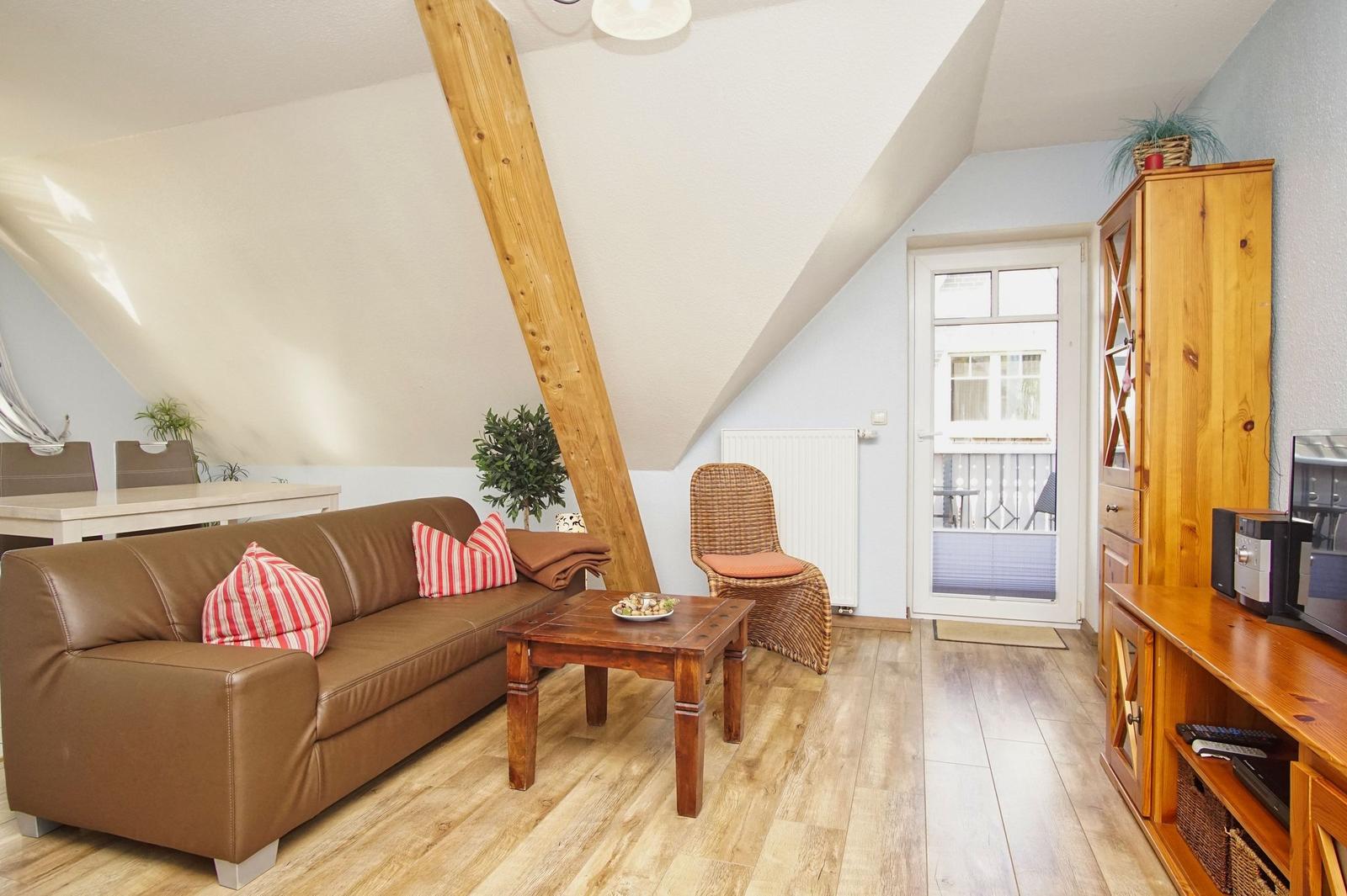 Wohnzimmer mit braunem Sofa, Holzfußboden und Kaminholzstruktur.