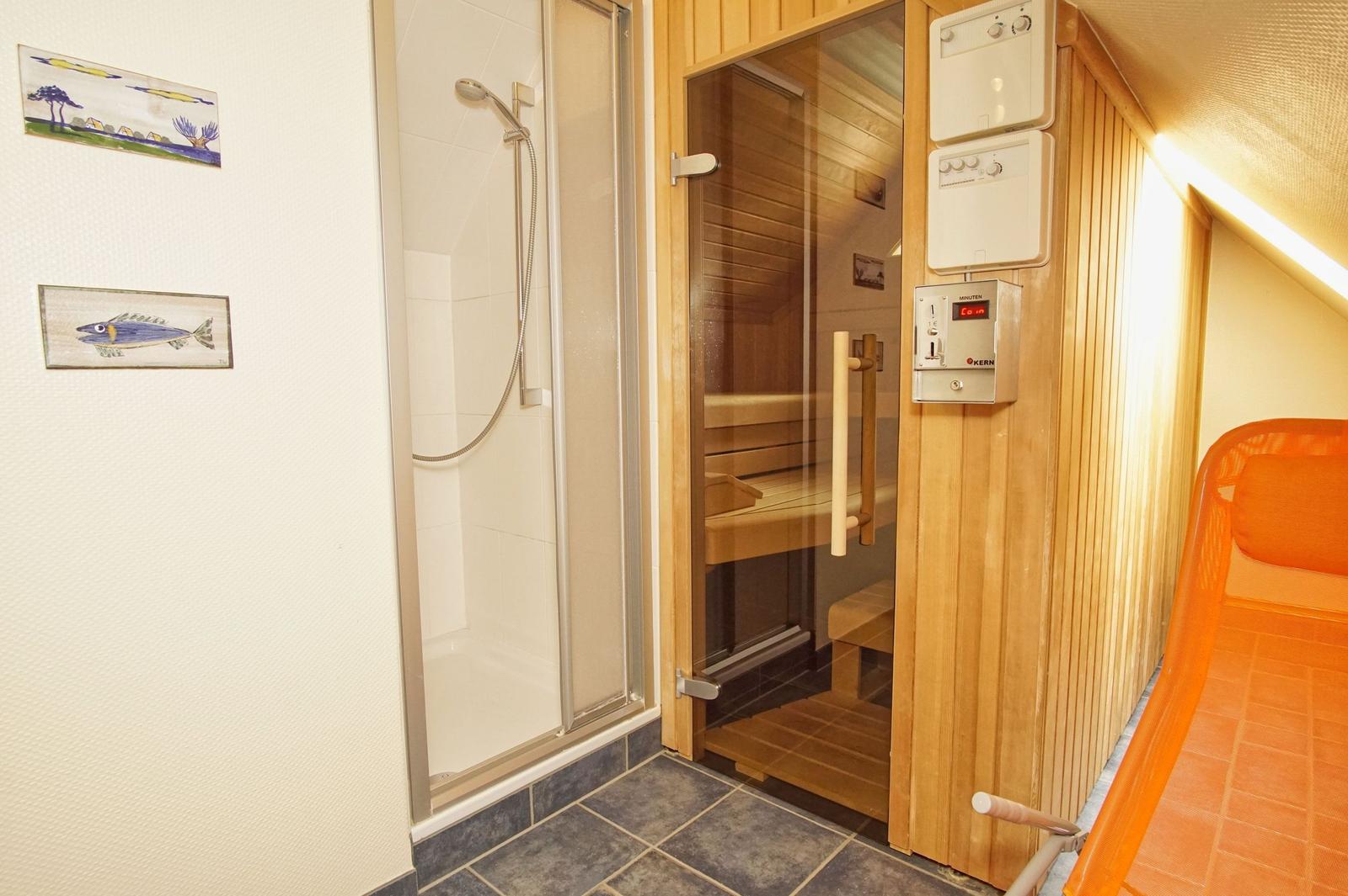 Dusche und Sauna mit orangefarbenem Liegestuhl