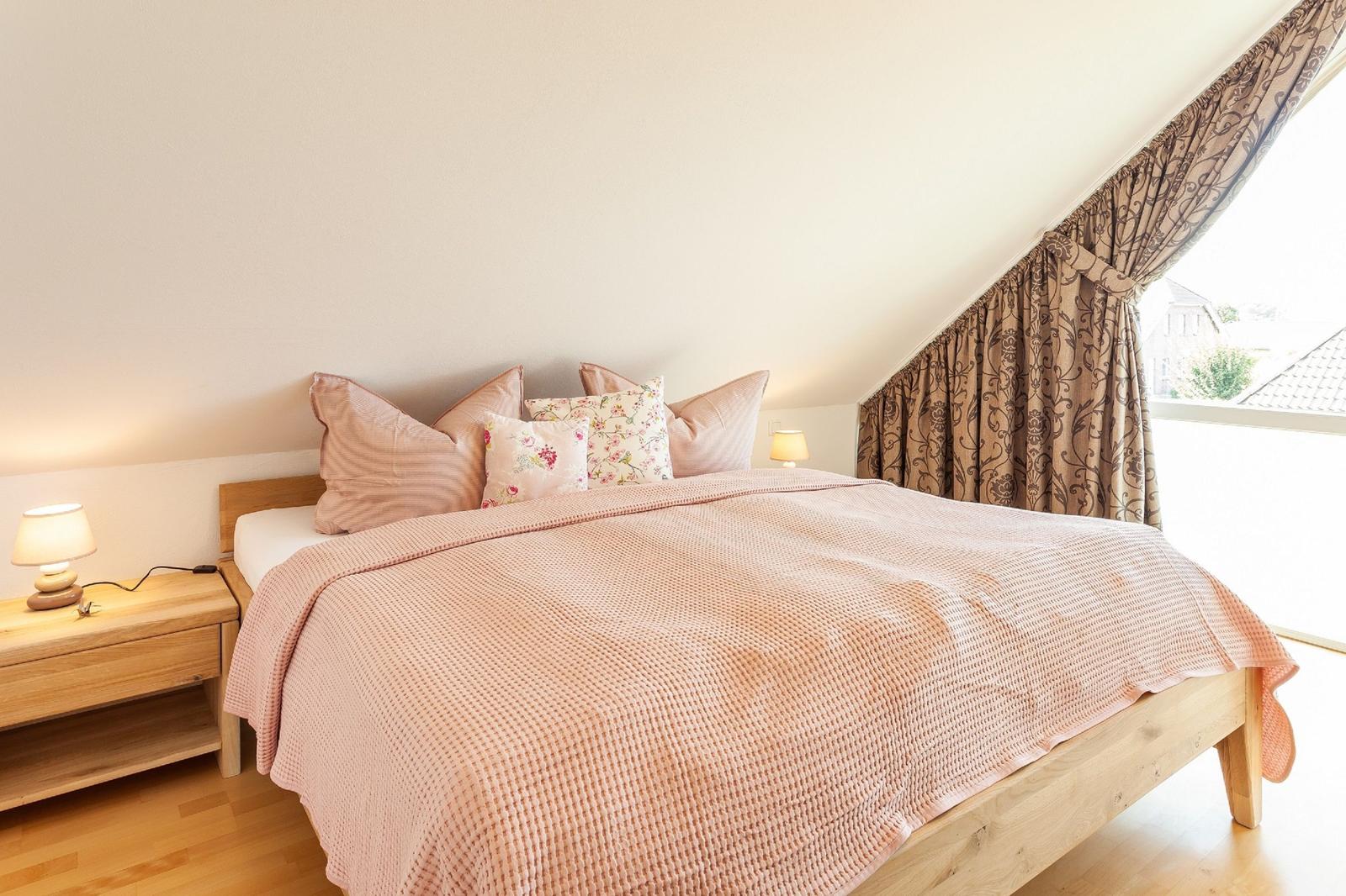 Schlafzimmer mit Bett, Nachttisch und Fenster