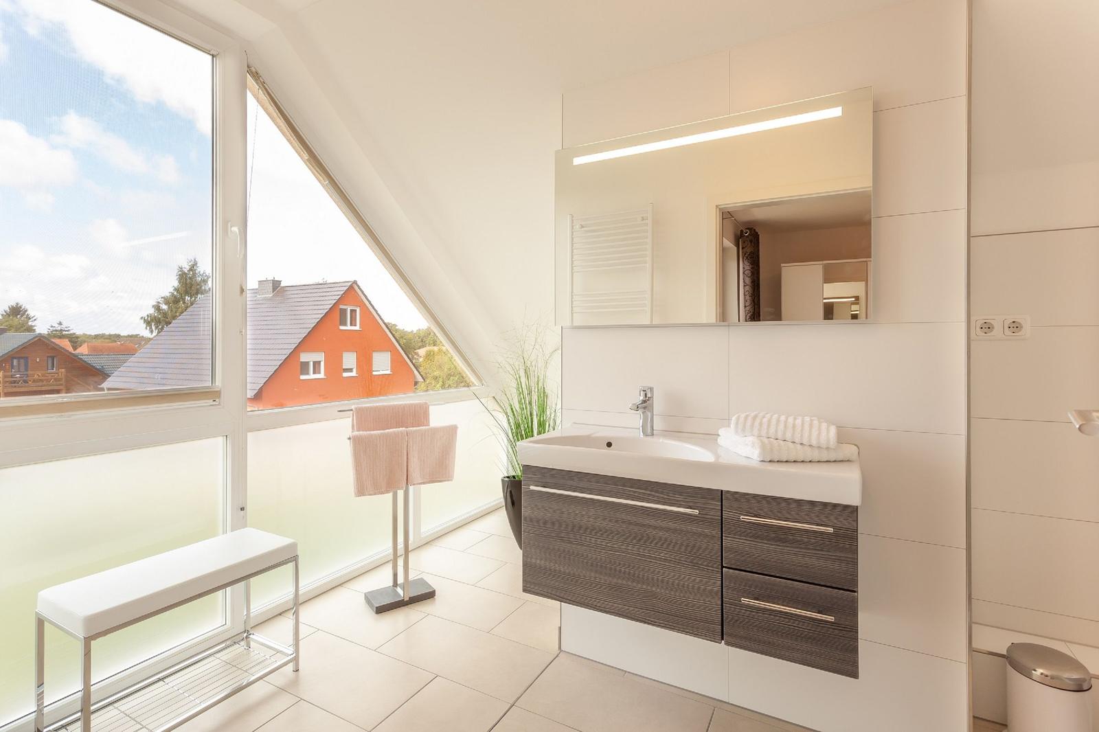 Badezimmer mit Dachschrägenfenster, Waschbecken und Spiegel