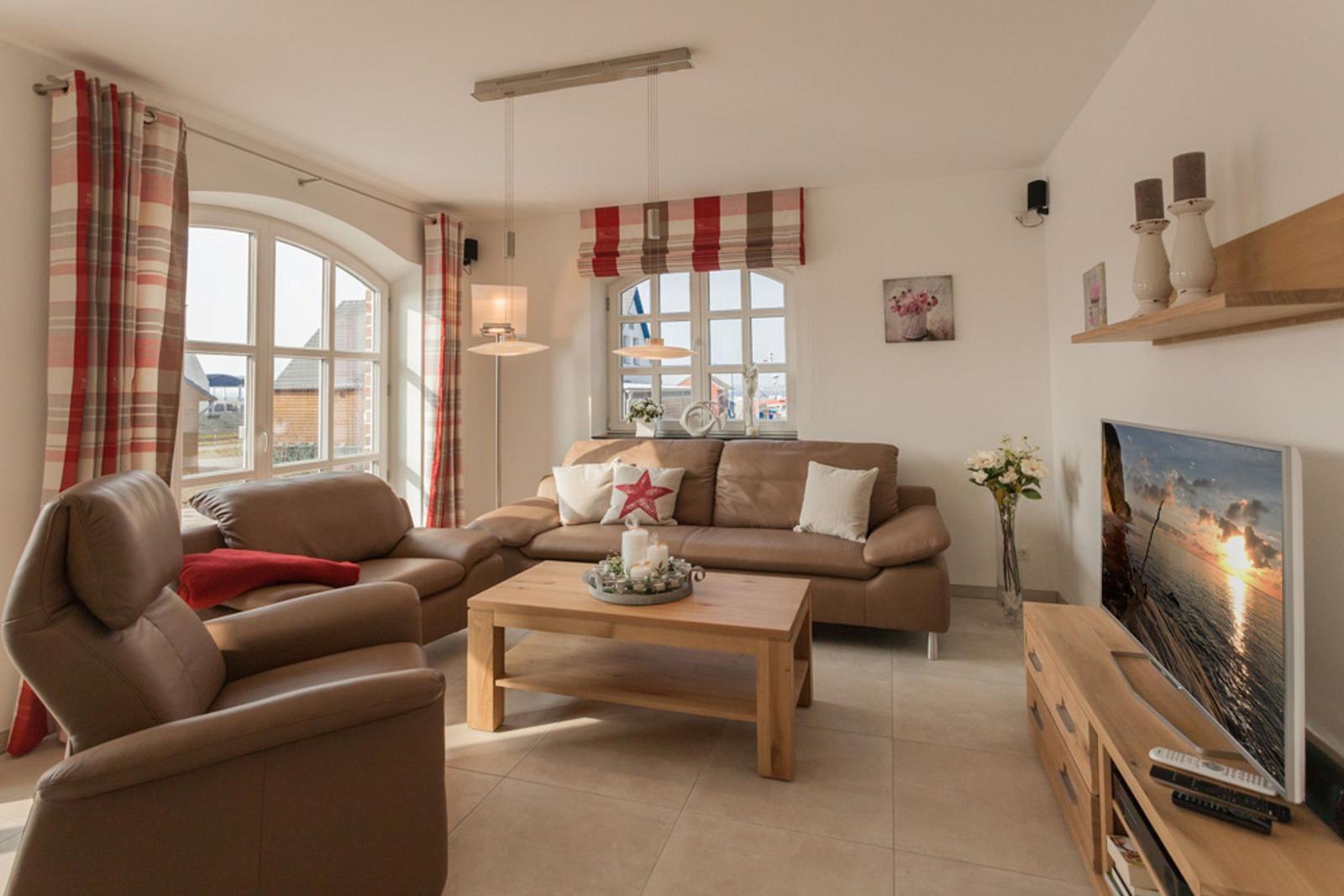 Wohnzimmer mit braunem Sofa, Holztisch und Fernseher.