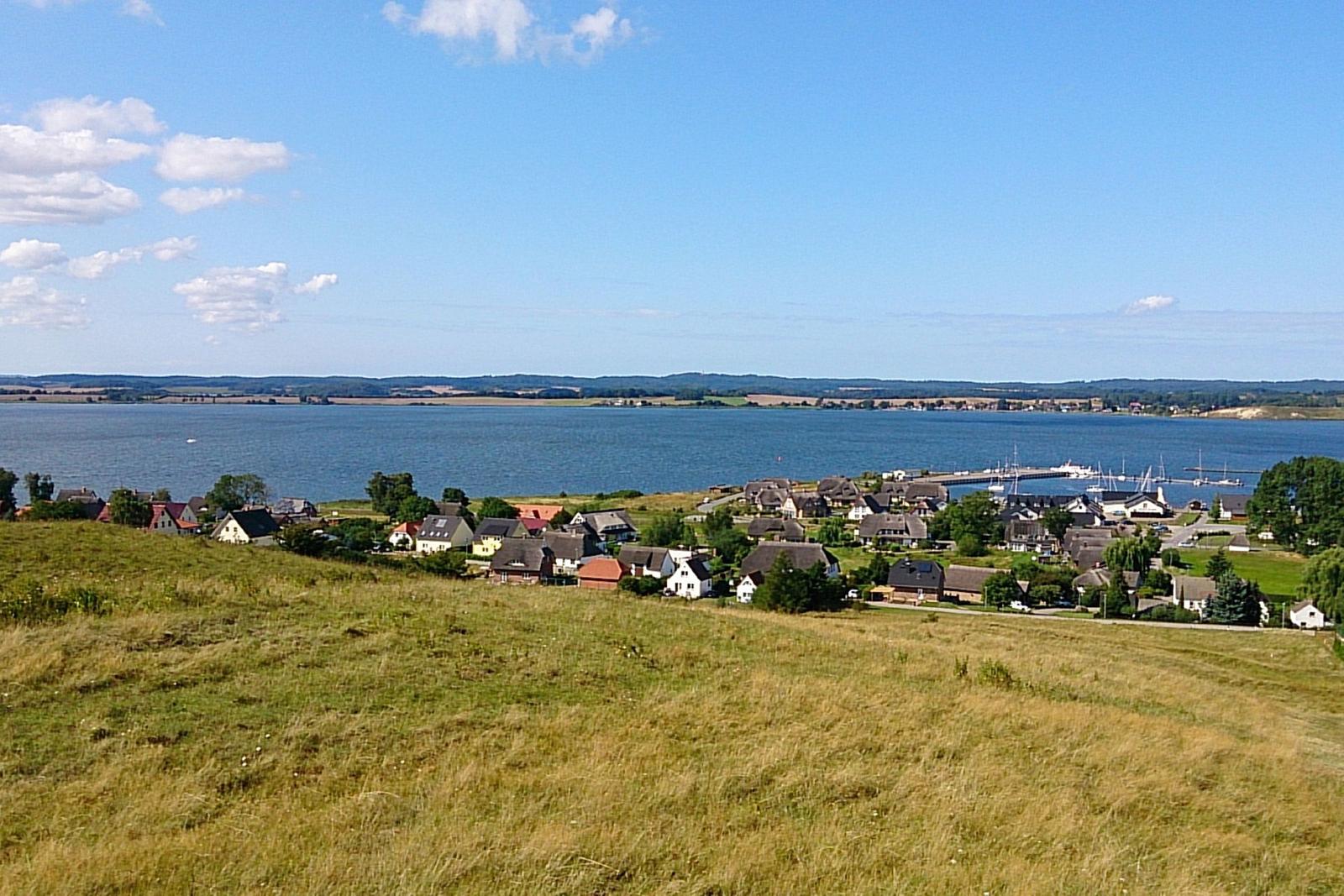 Panoramablick auf einen See mit einem Dorf und einem Hafen.
