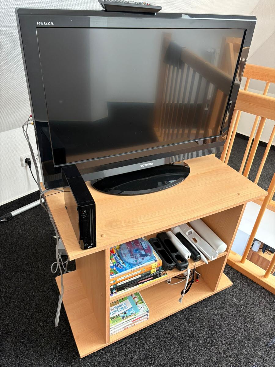 TV auf Holzregal mit Wii-Konsole und Spielen