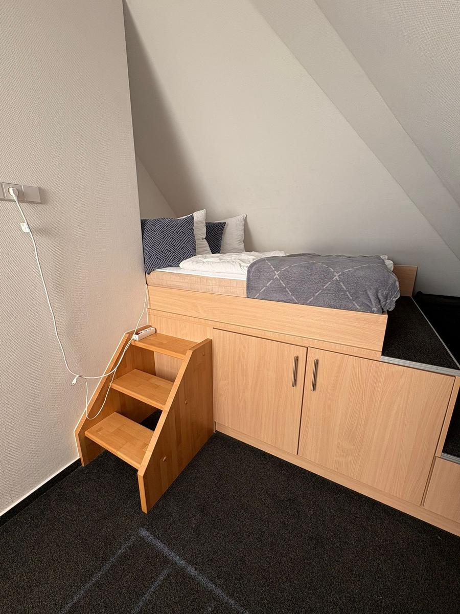 Ein Bett auf Hochbett mit Stufen und Schubladen
