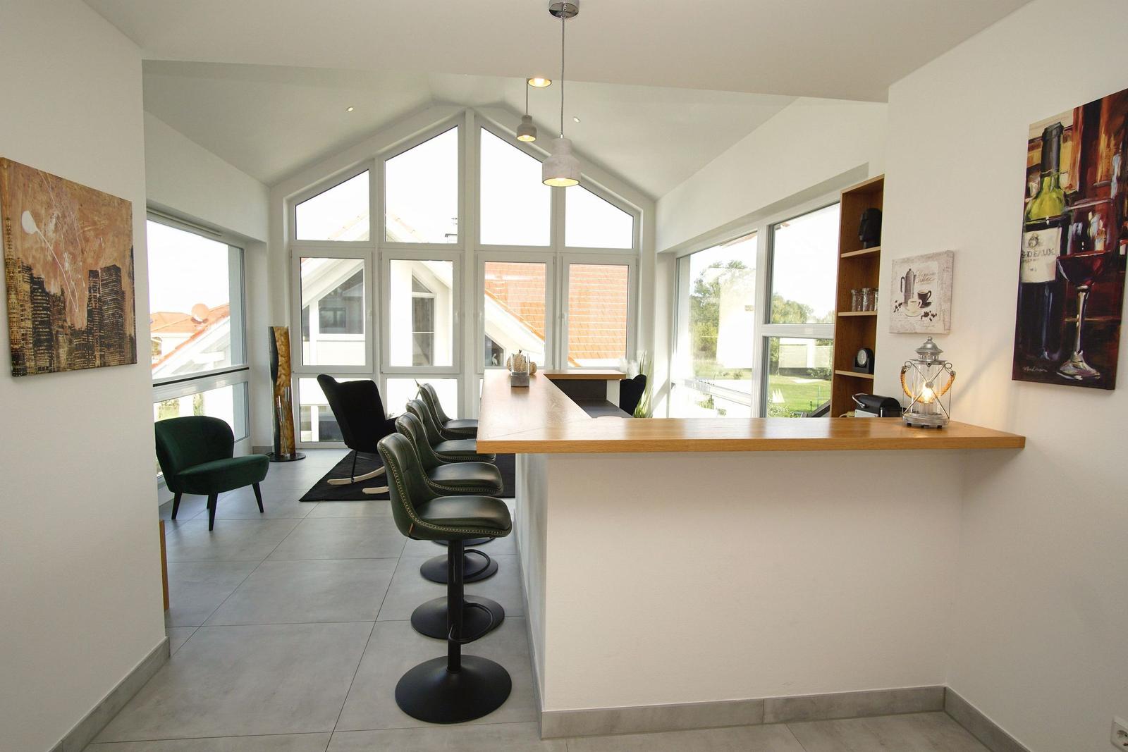 Barbereich mit grünen Barhockern und großen Fenstern zur Aussicht.