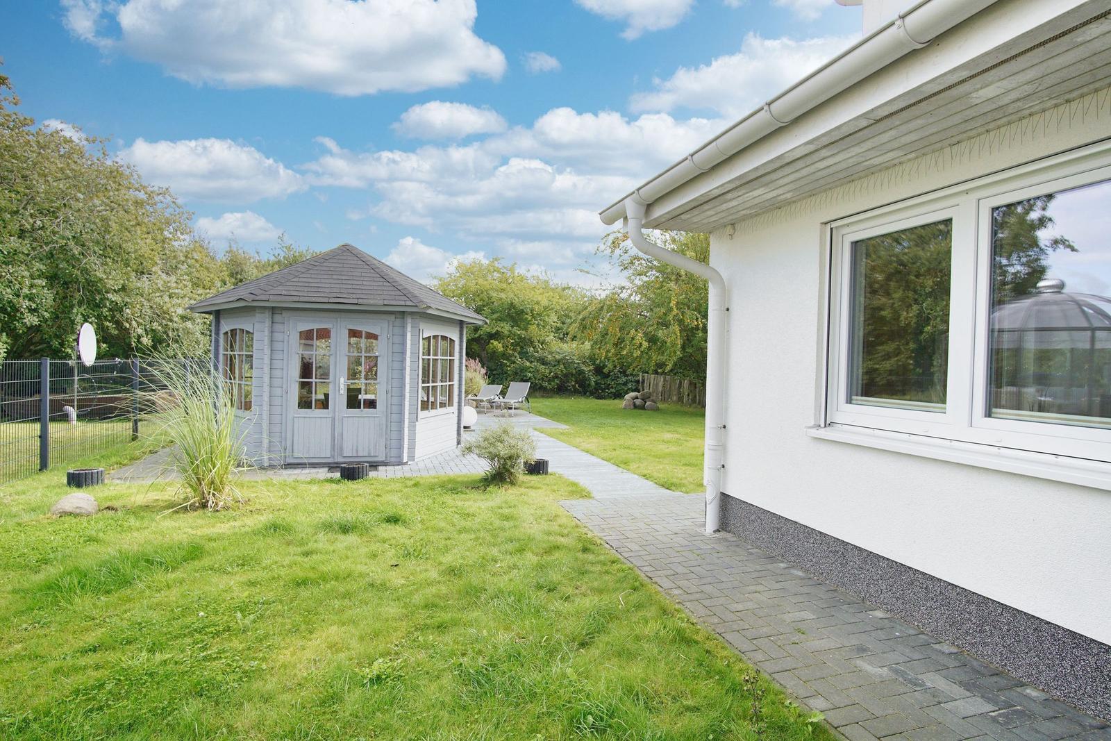Hinterhof mit Pavillon, Grillplatz und Gartenweg.