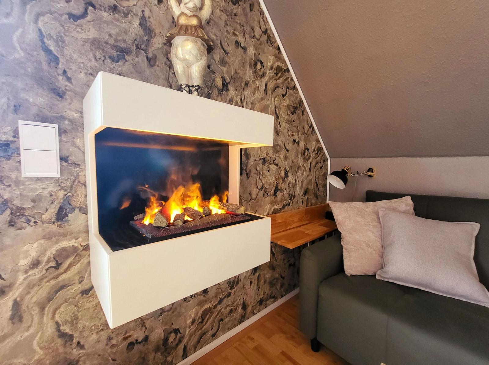 Wohnbereich mit Kamin und Sofa an steilem Dach