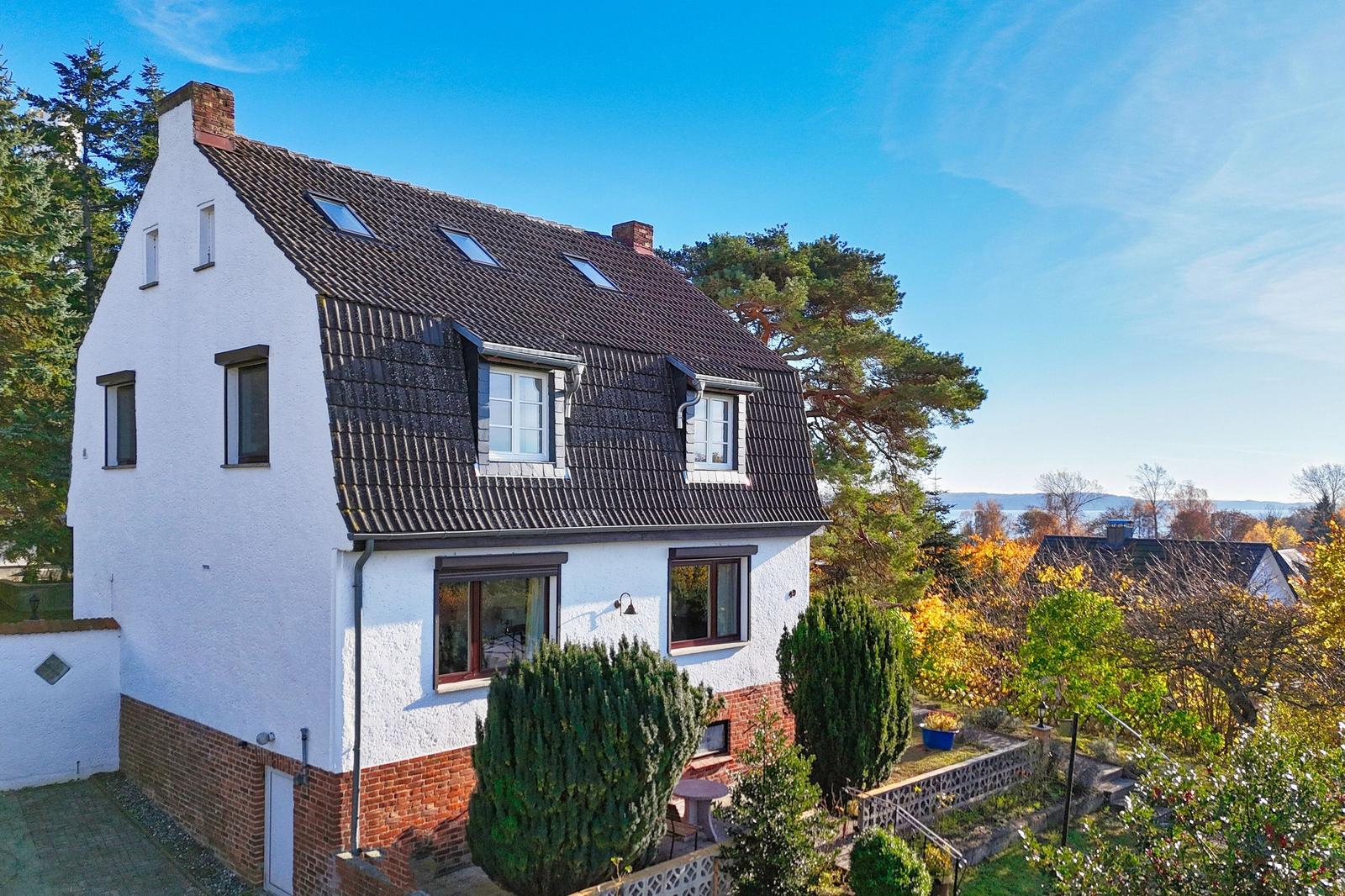 Haus mit Dachgauben, Garten und Blick auf Wasser