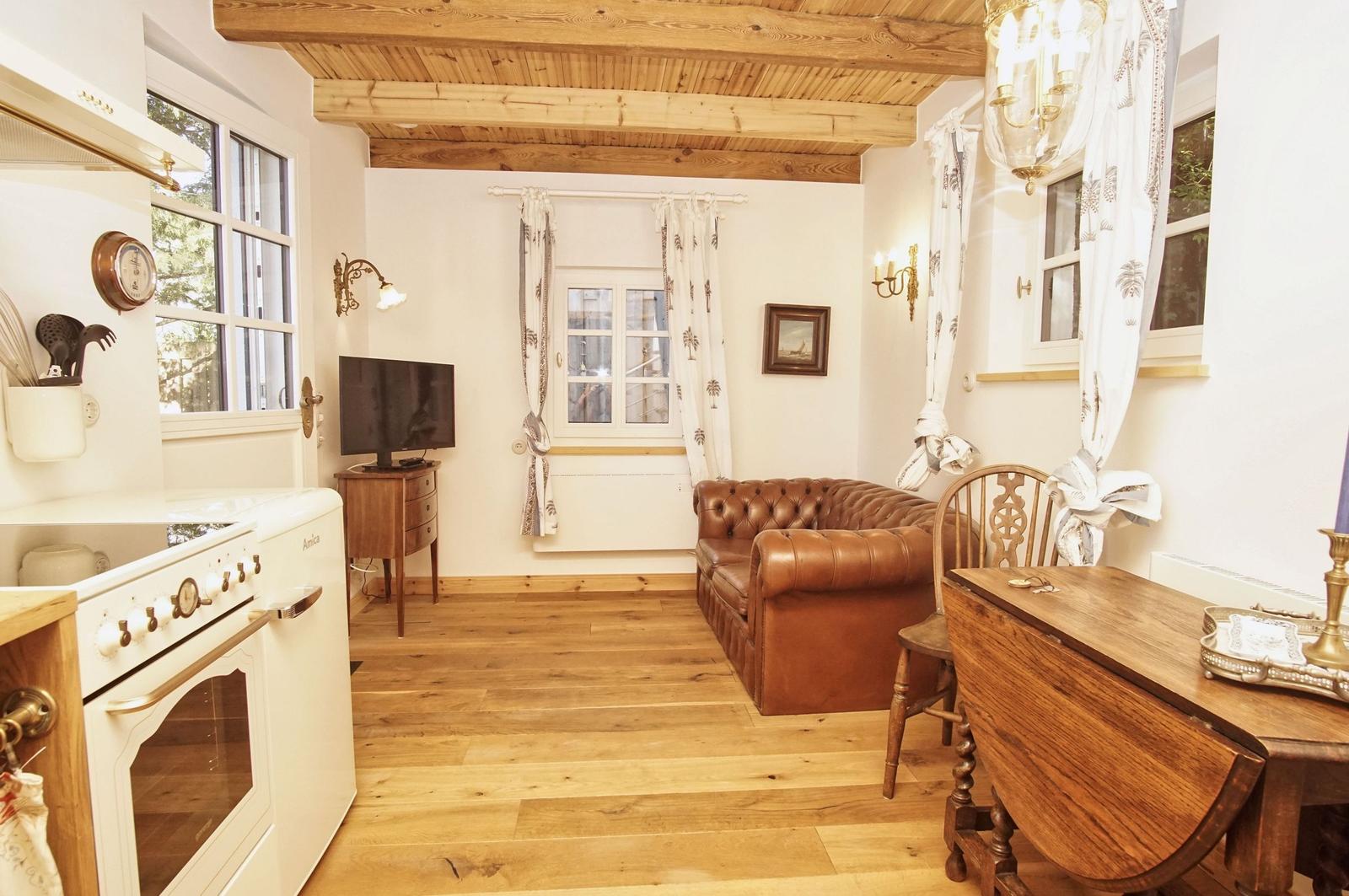 Küche mit Essbereich und Wohnbereich unter Holzbalkendecke