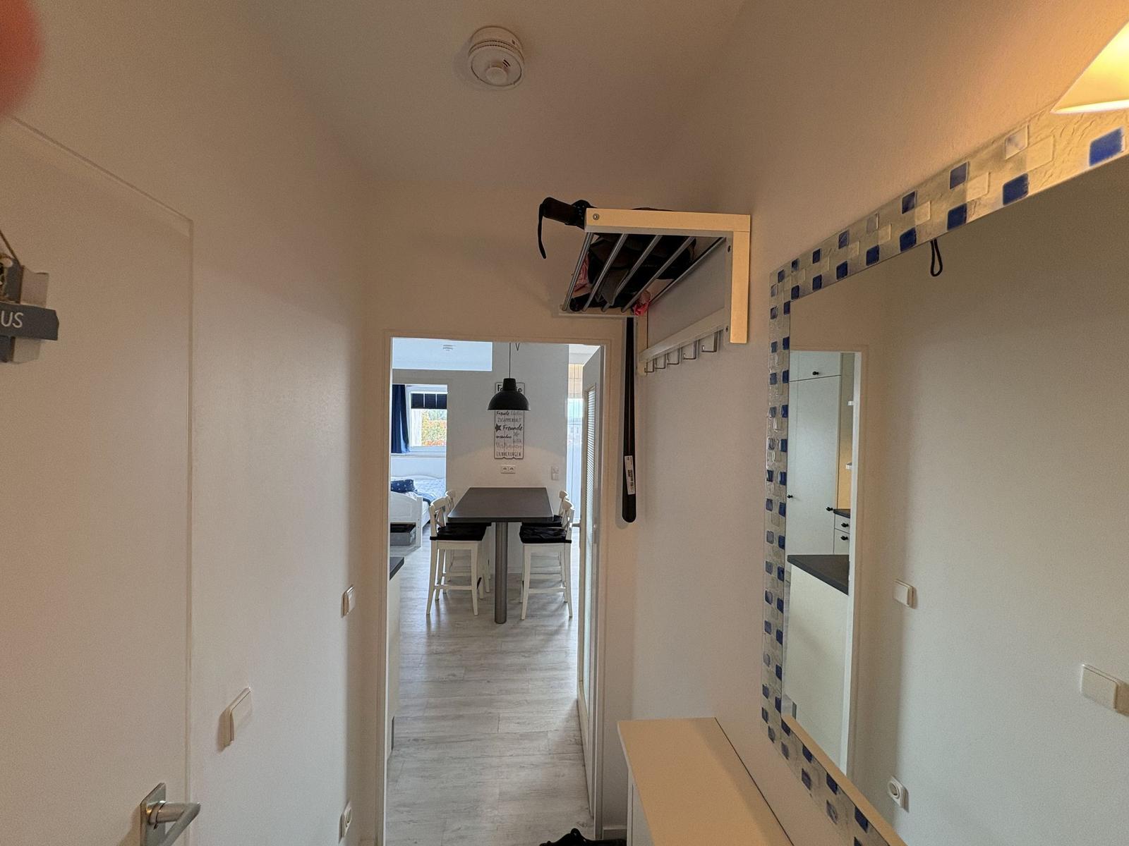 Flur mit Spiegel, Garderobe und Blick in Esszimmer.
