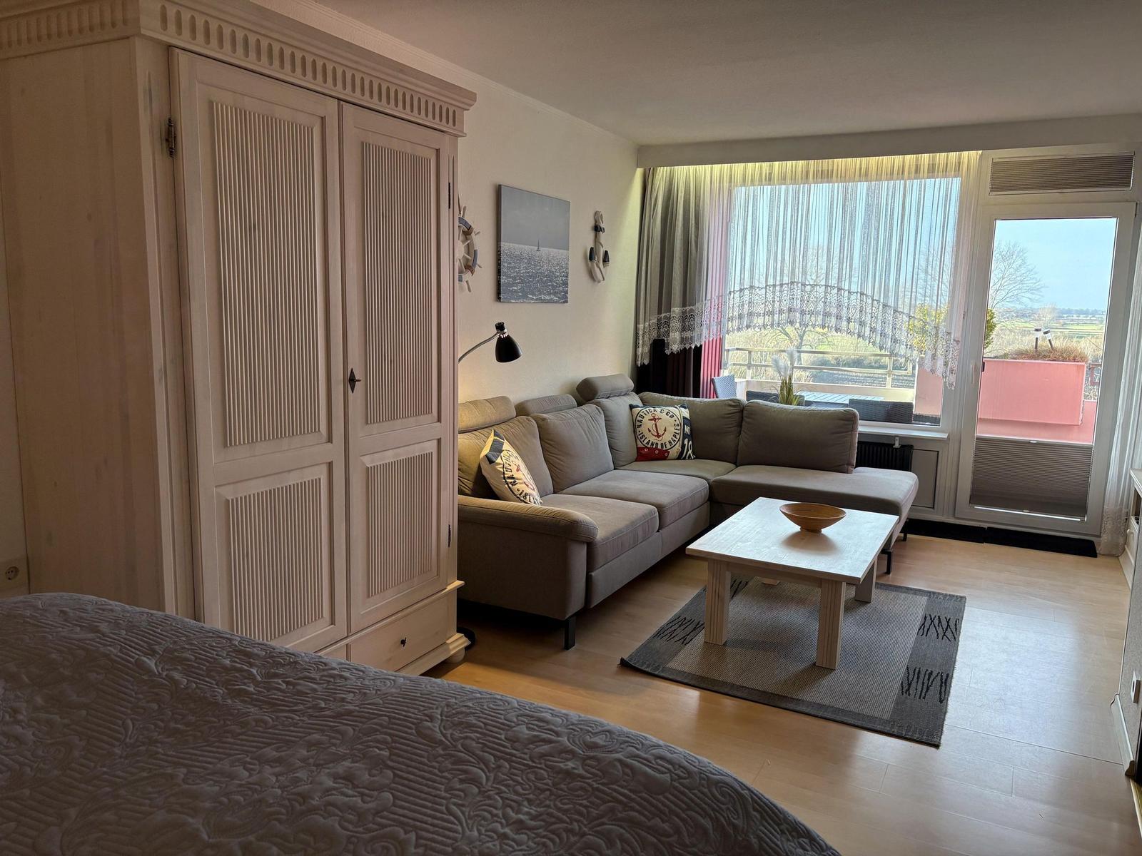 Wohnbereich mit Sofa, Couchtisch und Balkonansicht