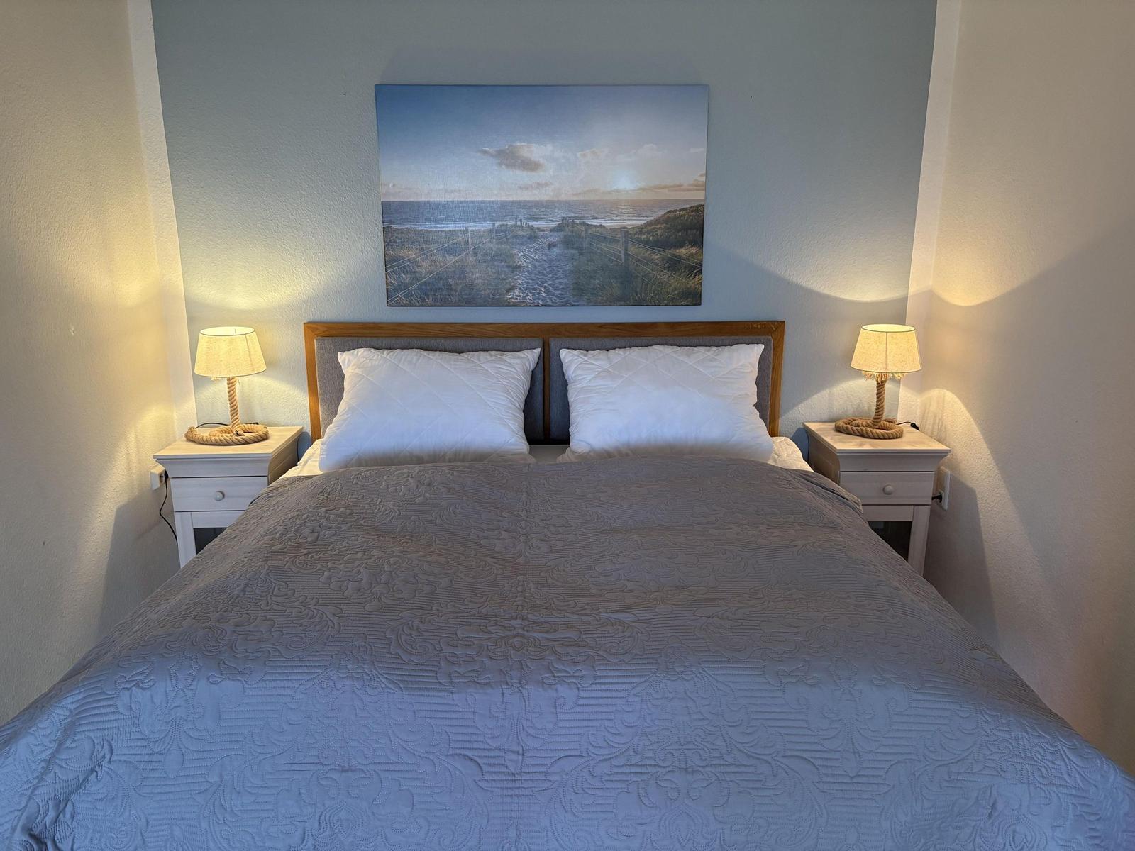 Doppelbett mit zwei Nachttischen und Wandbild im Schlafzimmer