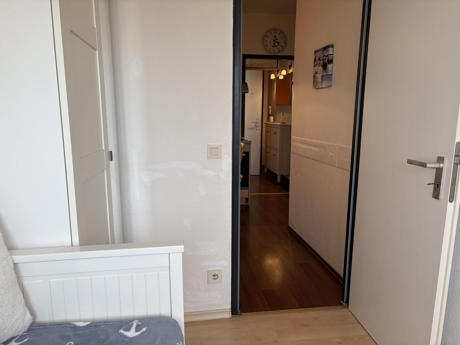 Schlafzimmer mit Blick in Flur und Küche.