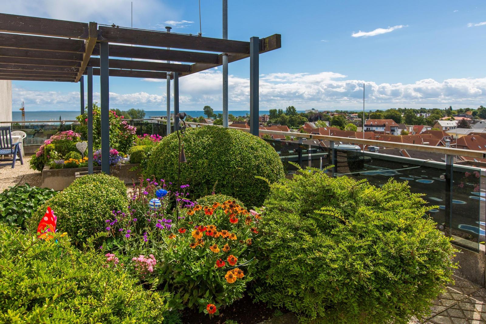 Terrasse mit Blumenbeeten und Blick auf See und Stadt