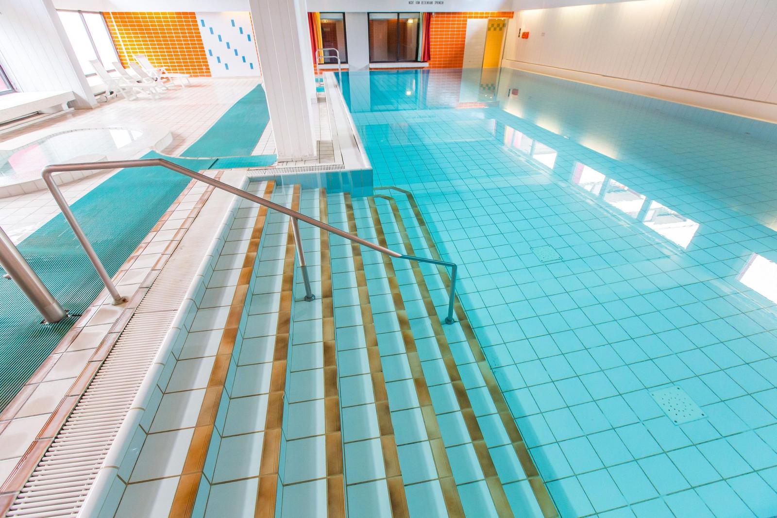 Innenpool mit Treppe und Liegewiesen