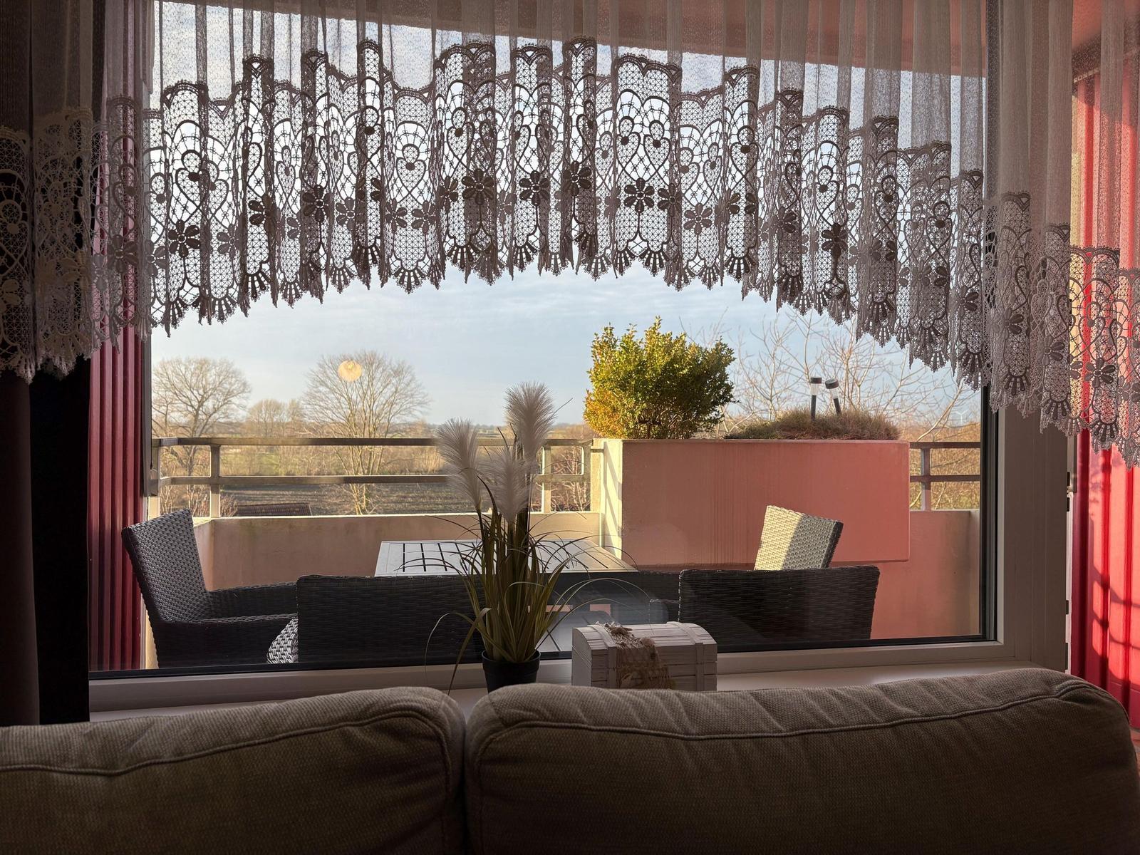 Blick auf Balkon mit Sitzgelegenheiten und Blick auf Landschaft.