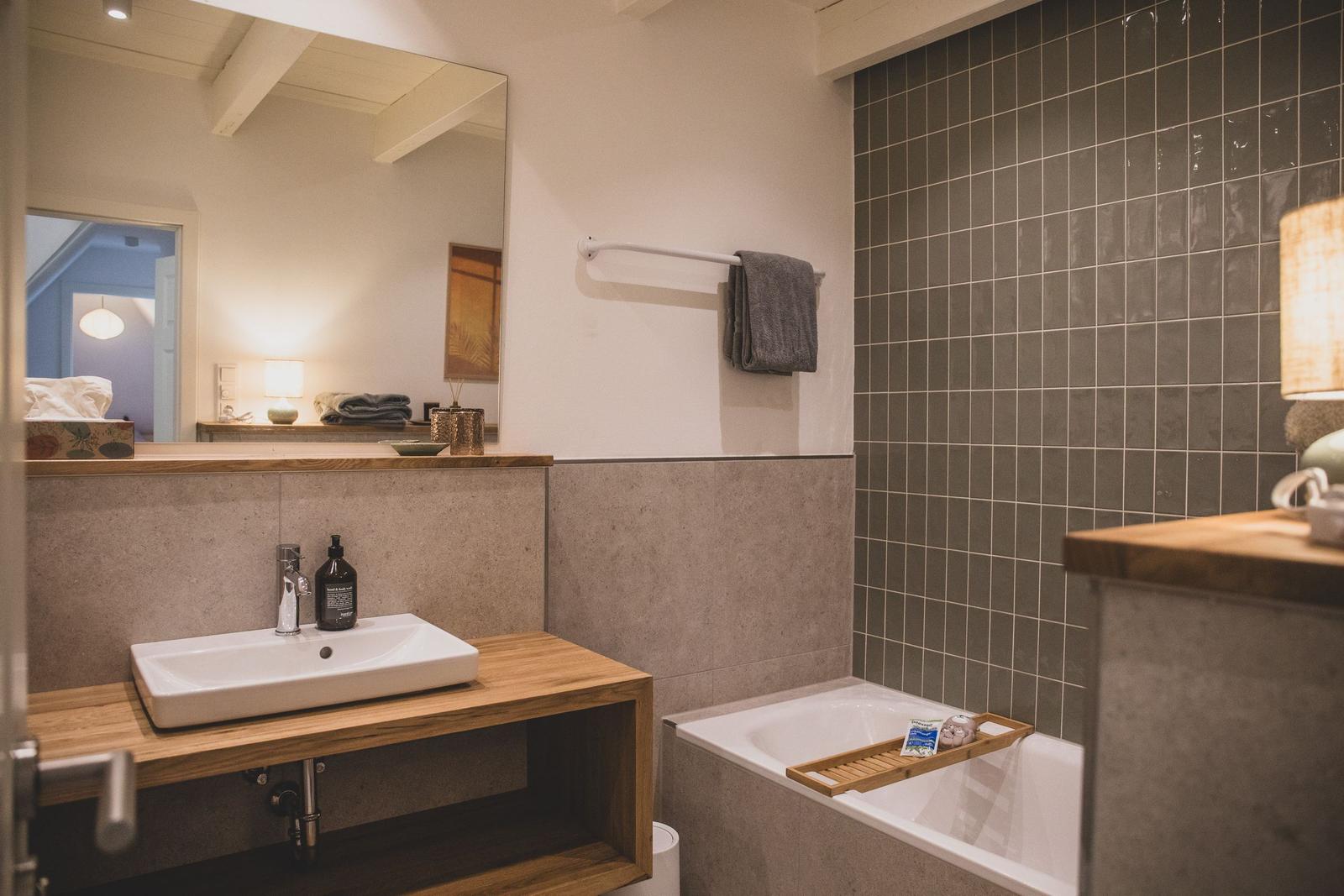 Badezimmer mit Badewanne, Waschbecken und Spiegel