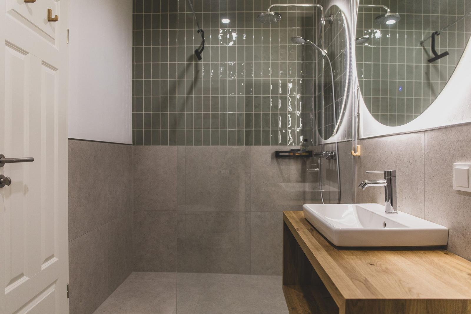 Badezimmer mit Dusche, Waschbecken und Spiegel