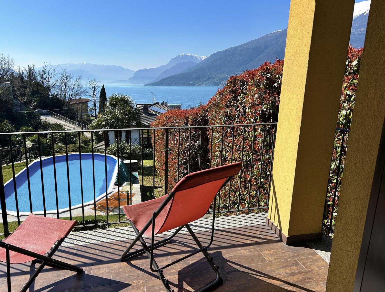 Terrace with loungers and view of pool and lake