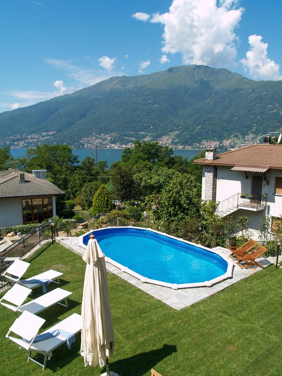 Pool with loungers and view of lake and mountains.