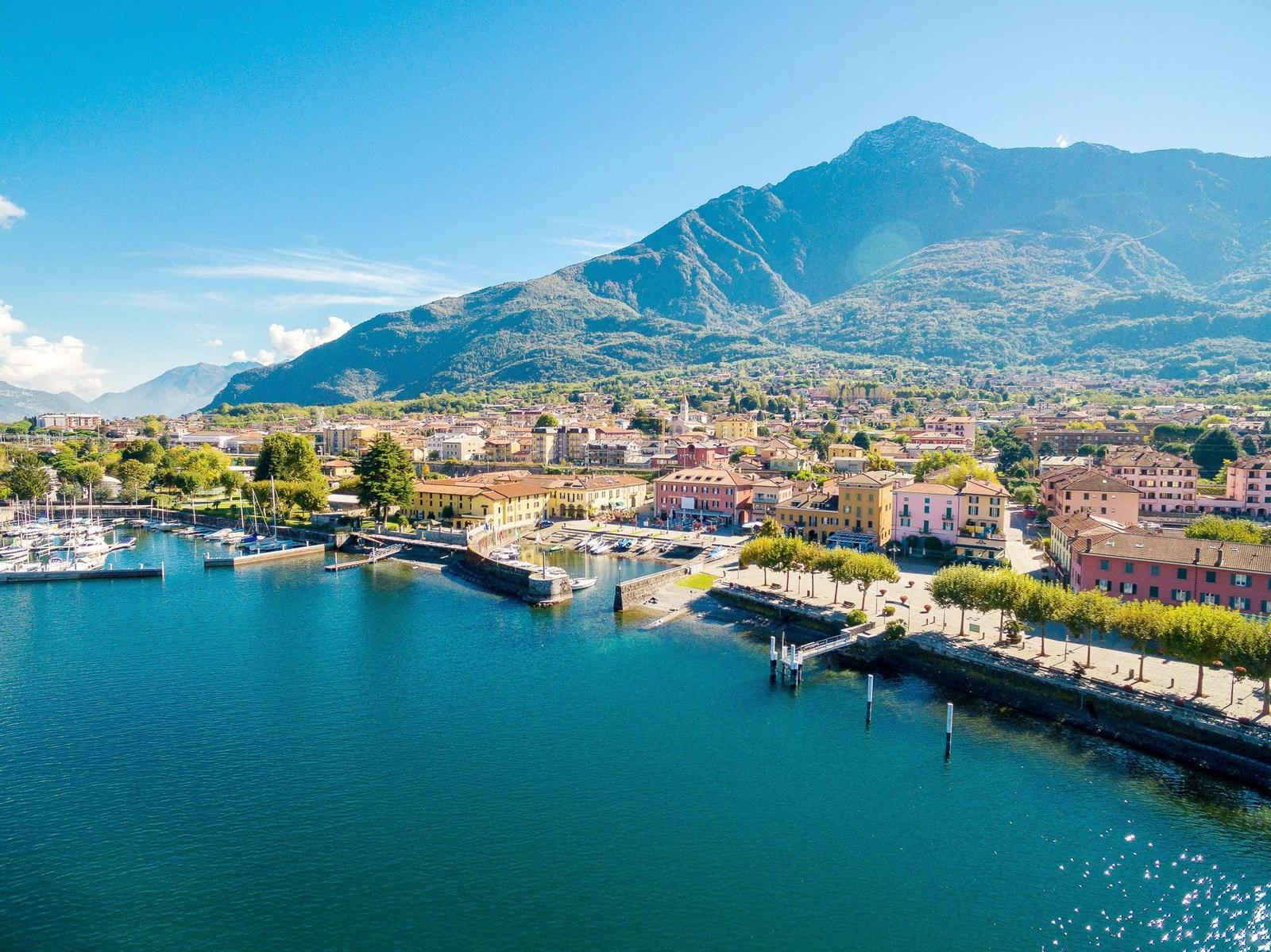 Town by the harbor with boats and mountains in the background