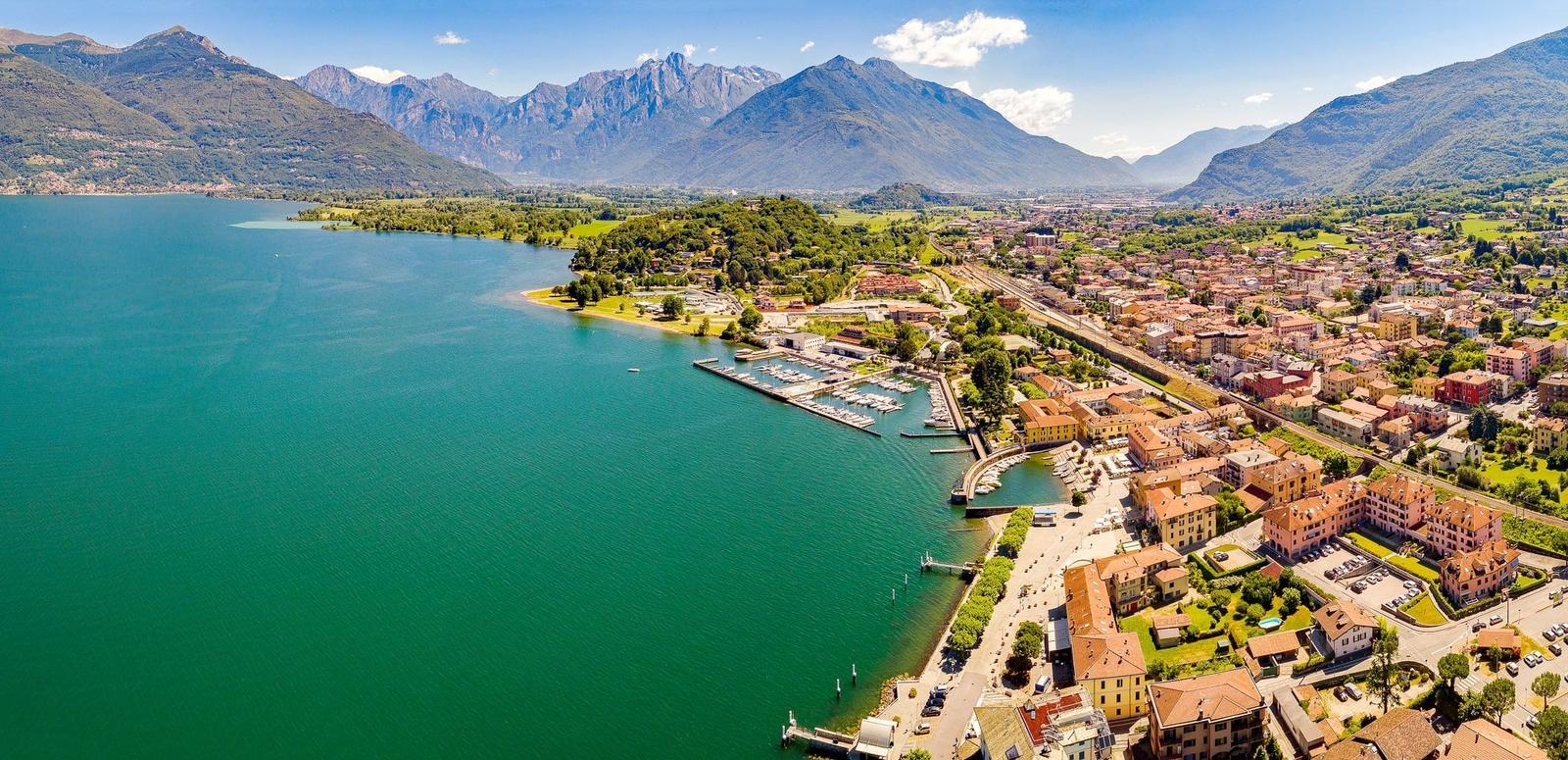 Town by lake with marina and mountains in background
