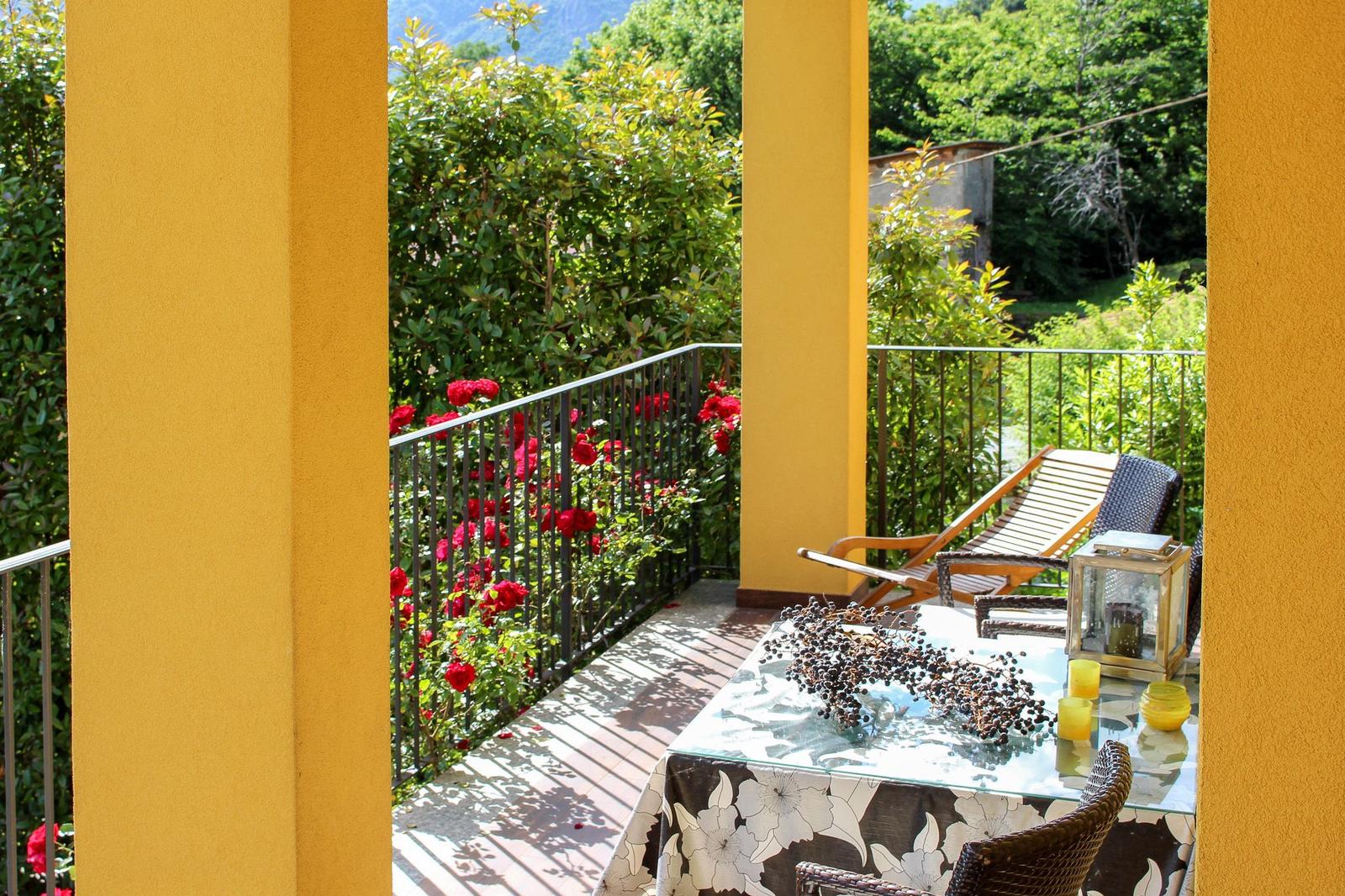 Terrace with table, chairs, and view of rose garden.